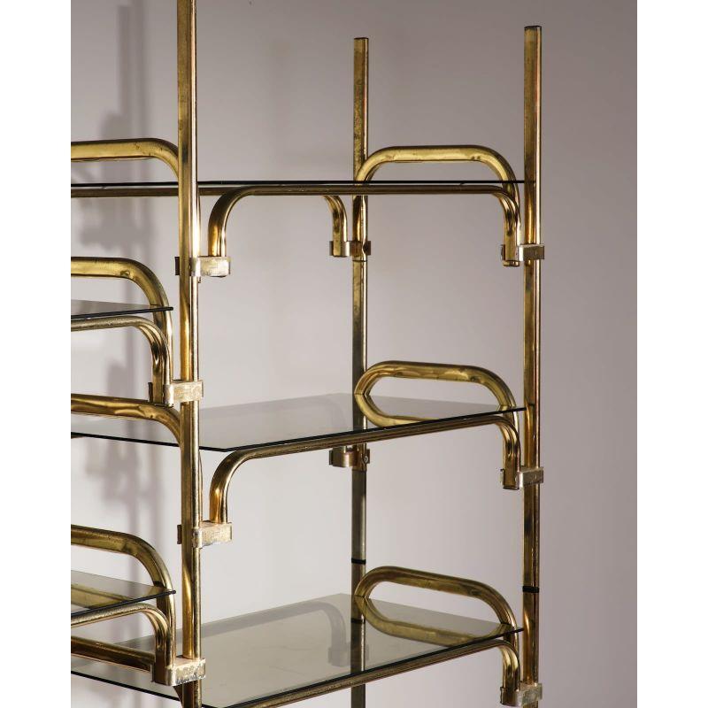 Italian modular shelving unit in metal and glass, c.1980s.

Gilded metal and glass.

Dimension: W 230 x D 42 x H 182 cm.
 