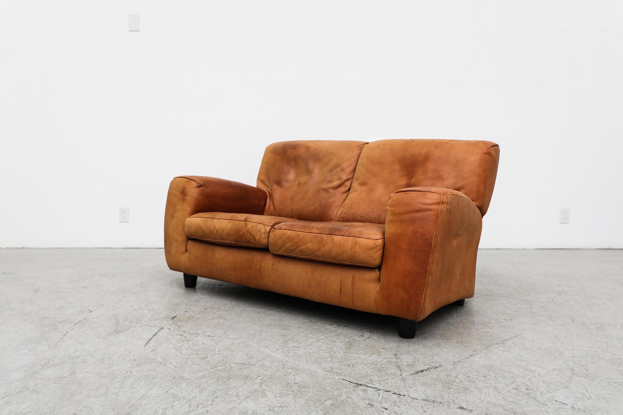 Italian Molinari ‘Fatboy’ two-seat sofa in cognac leather. In original condition with visible wear and heavy patina, including sun faded leather on the back right side. Wear is consistent with its age and use.
