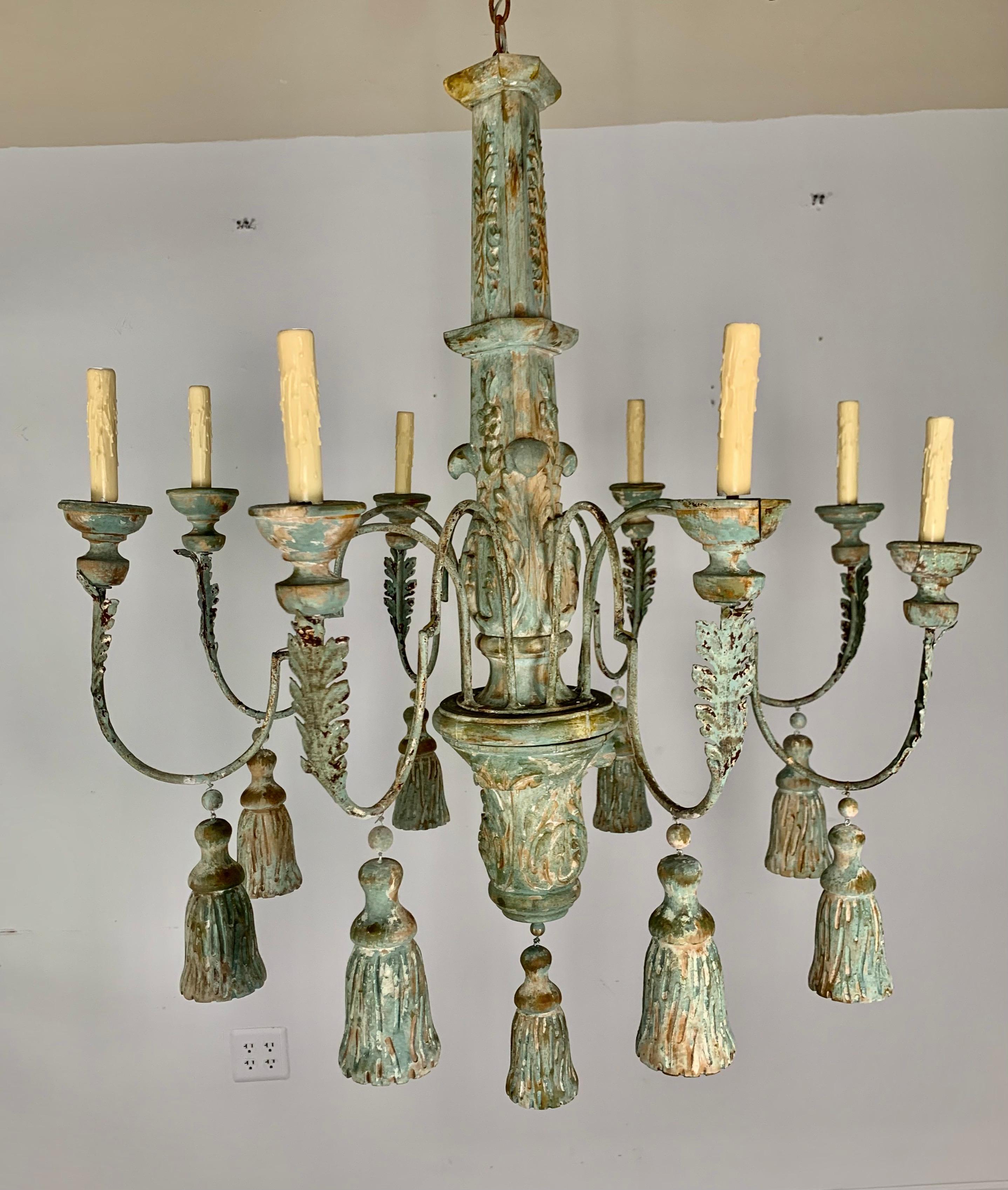 Ten light wood & iron painted chandelier with hand carved tassels hanging throughout. The fixture is newly rewired and includes chain and canopy. The chandelier has a beautiful worn painted finish that shows the wood underneath.