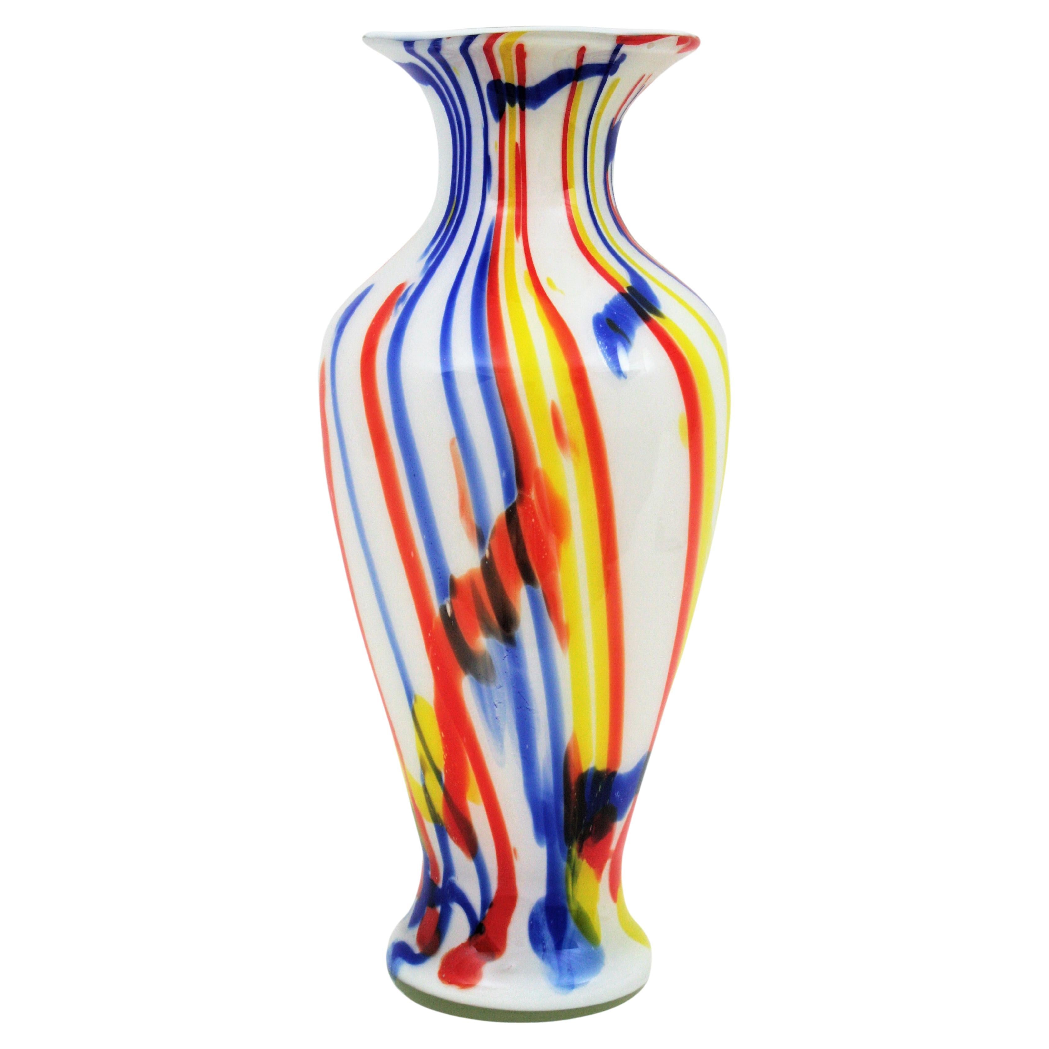 Übergroße weiße mundgeblasene Murano-Kunstglasvase mit mehrfarbigen Streifen, Italien, 1960er Jahre.
Große Vase aus mundgeblasenem weißem Murano-Glas mit buntem Murrinendekor in Rot, Gelb und Blau.
Wunderschön von allen Seiten und sehr groß.
Kann