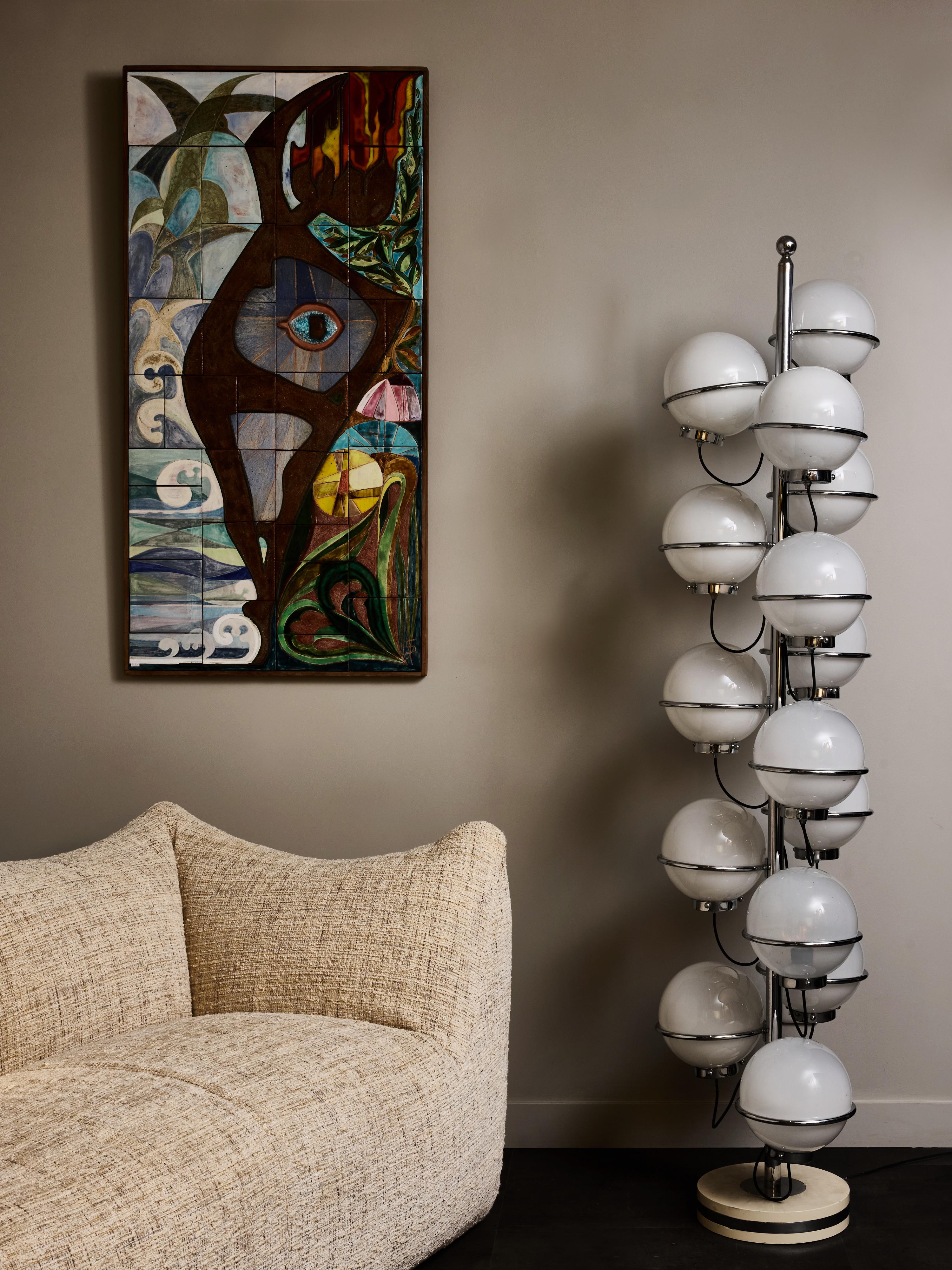 This striking Italian floor lamp from the 1980s features a dramatic vertical arrangement of illuminated opaline glass globes set on a polished chrome structure. The design is both sculptural and architectural, with fifteen spherical diffusers