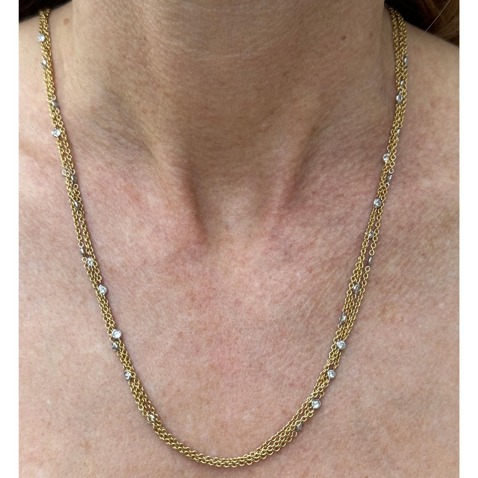 Beautiful multi strand diamond by the yard necklace crafted in 18 karat yellow gold. The necklace features multiple link chains bezel set with 28 round brilliant cut diamonds weighing approximately 1.40 carat total weight. The diamonds are graded