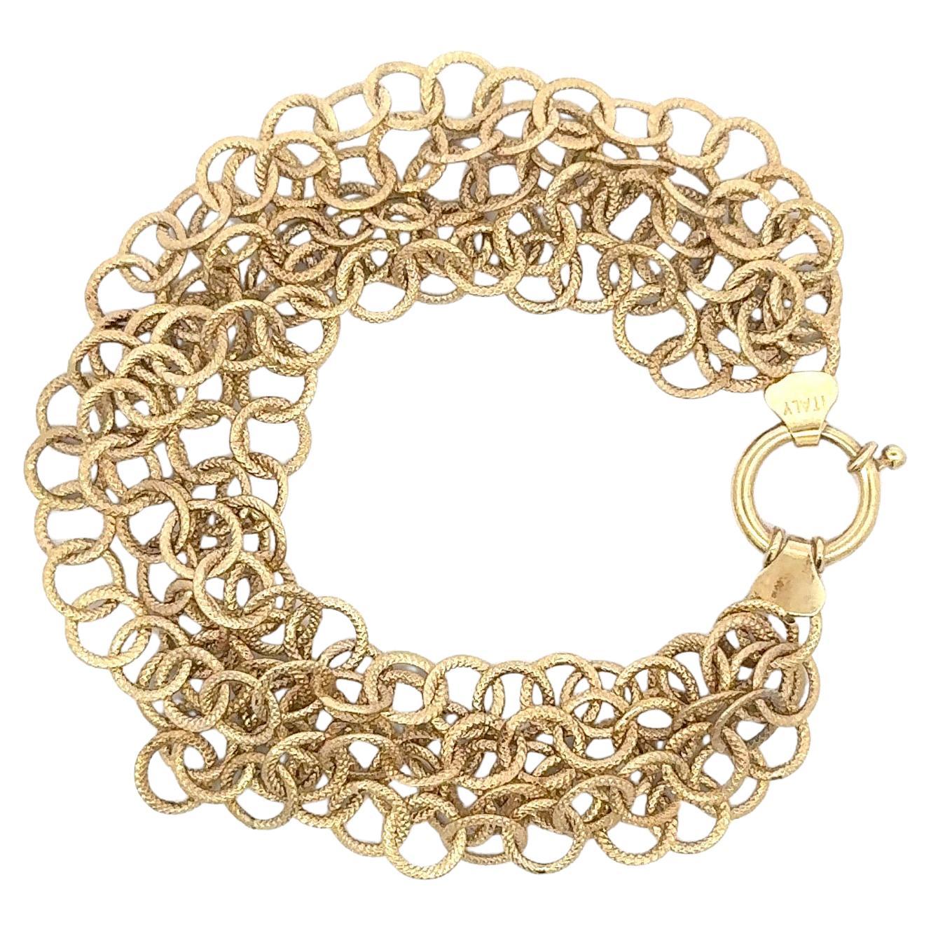 Bracelet en or jaune 14 carats composé de 5 rangs de maillons circulaires tressés pesant 8,8 grammes, 7,25 pouces.
Fabriquées en Italie. 