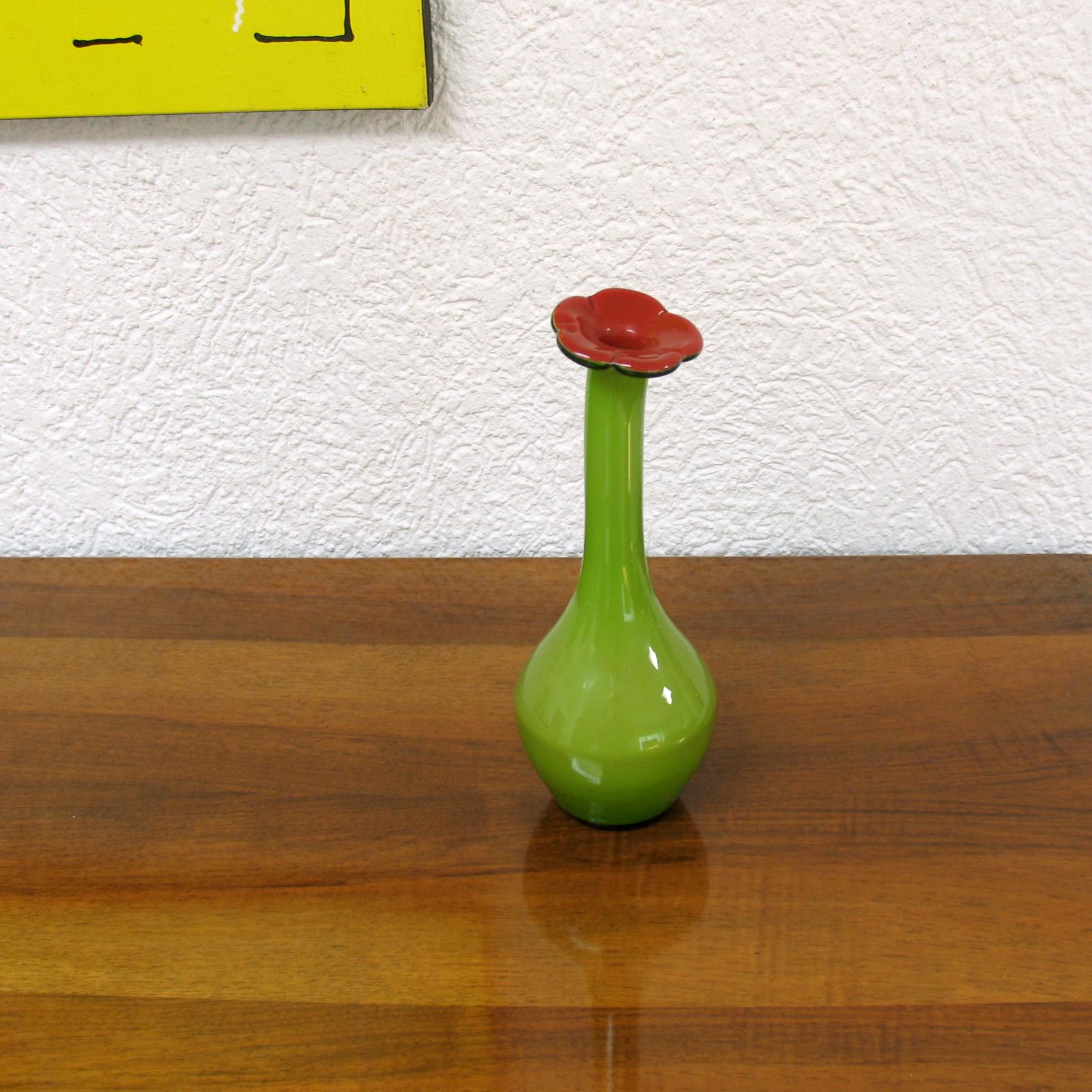 Vase de forme intéressante, dont le bec est terminé par une fleur. De belles couleurs vives. Verre à trois couches, formé à la main. Label d'origine sur le fond. Parfait état.
Dimensions :
28,5 cm de hauteur, 10 cm de diamètre
Ce magnifique vase
