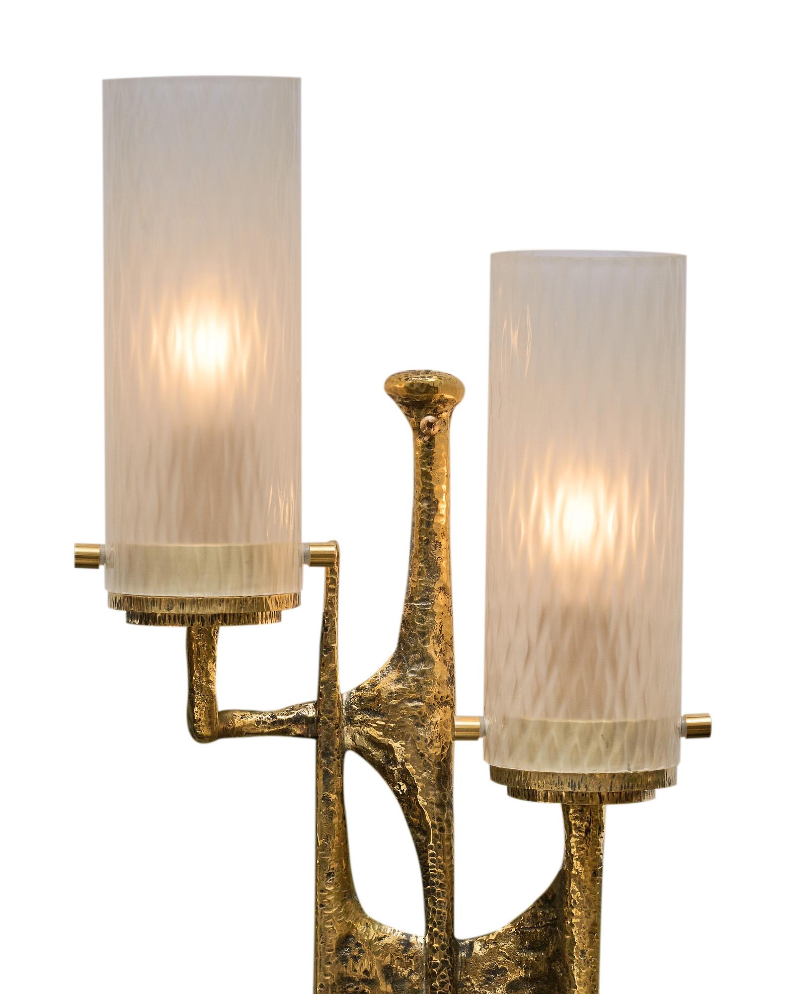 Pair of wall sconces, in the Brutalist style, with hammered bronze structures each gilded and topped with two Murano glass cylindrical shades. We are drawn to the unique style and hand-crafted elements of the high-quality materials. They have been