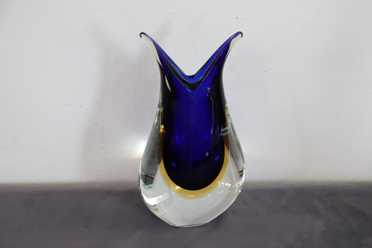 Italian desgn circa 1970s murano art glass blue, yellow and transparent vase. A beautiful vase with intense colours, the blue has a unique quality and intensity. The presence of the original vintage label is a real rarity. Made by Formia, a historic