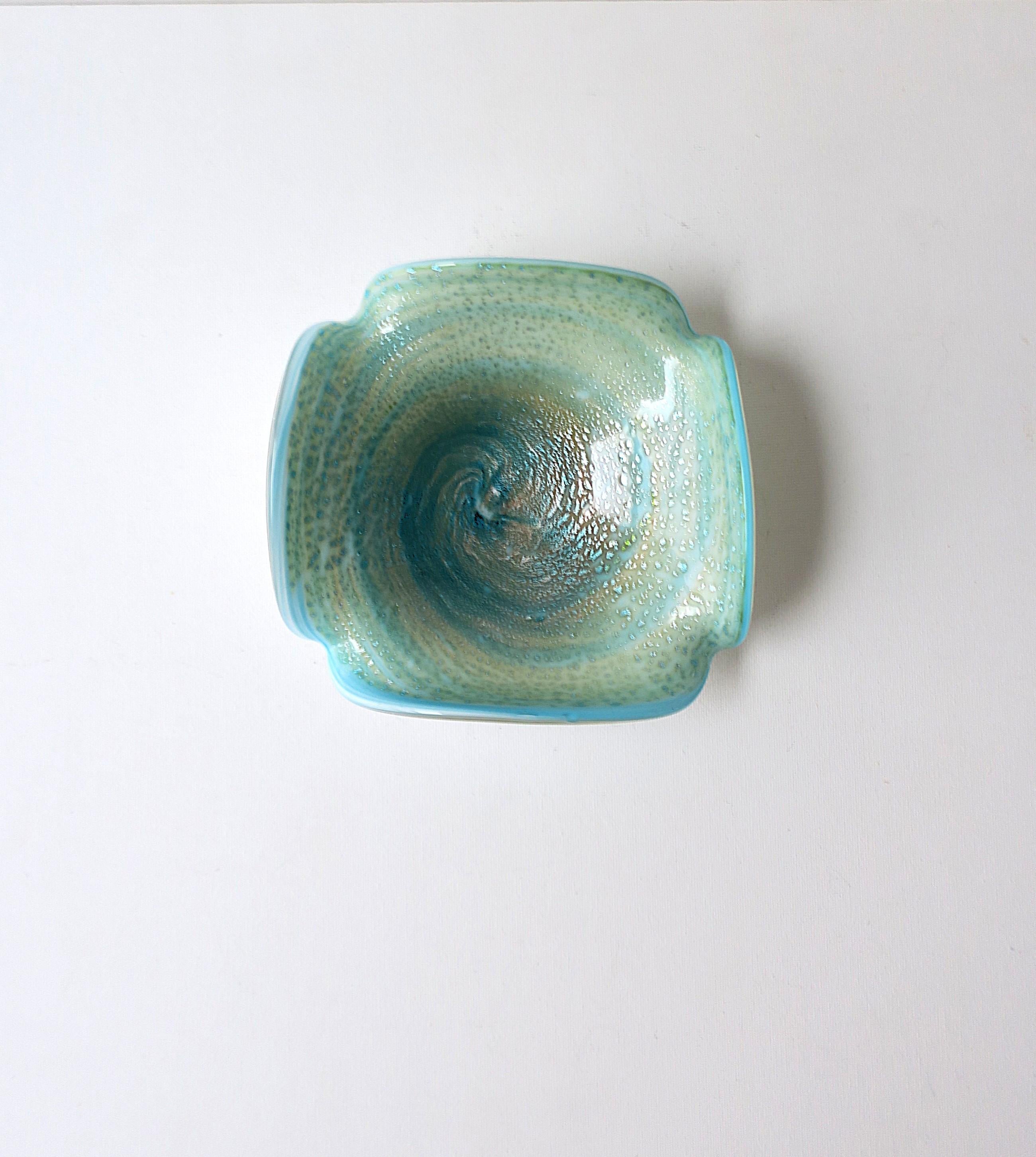 A beautiful Italian Murano art glass bowl, Italian Midcentury Modern design period, circa mid-20th century, Italy. Bowl has a white underside base merged with an aqua or turquoise blue, swirled with silver leaf. Beautiful as a standalone piece,