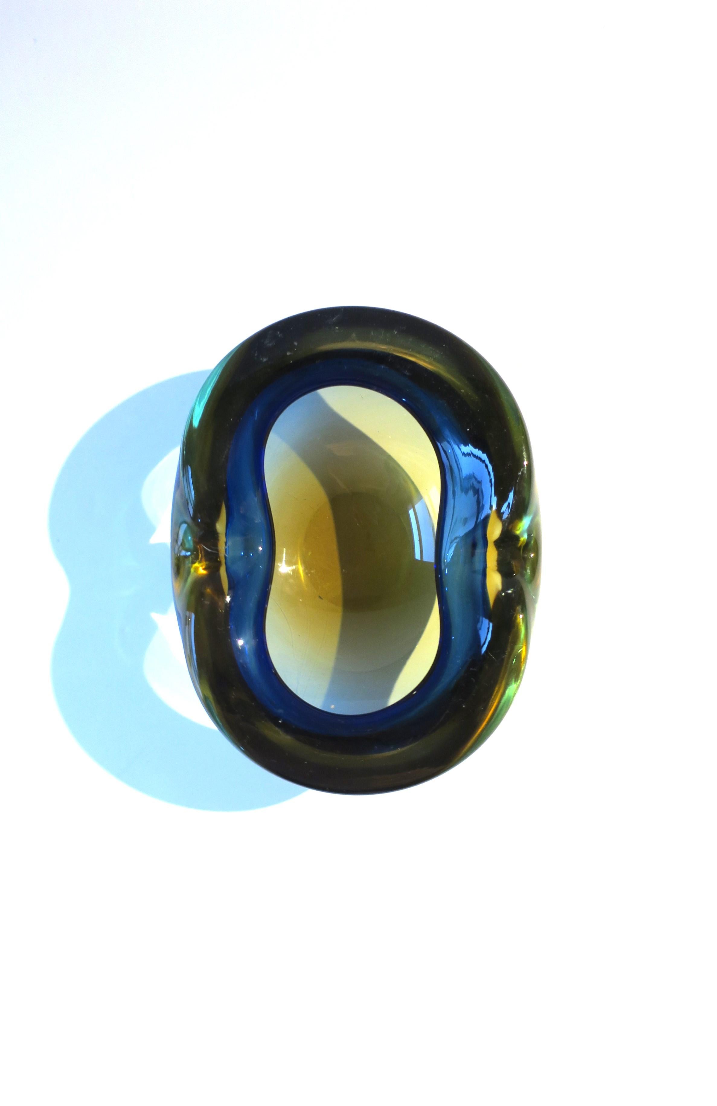 A substantial vintage Italian Murano hand blown Sommerso art glass bowl or ashtray in the style of artist Alfredo Barbini, Midcentury Modern period, circa 1950s, 1960s, Italy. Piece is dark blue, yellow and transparent/clear art glass, oval in