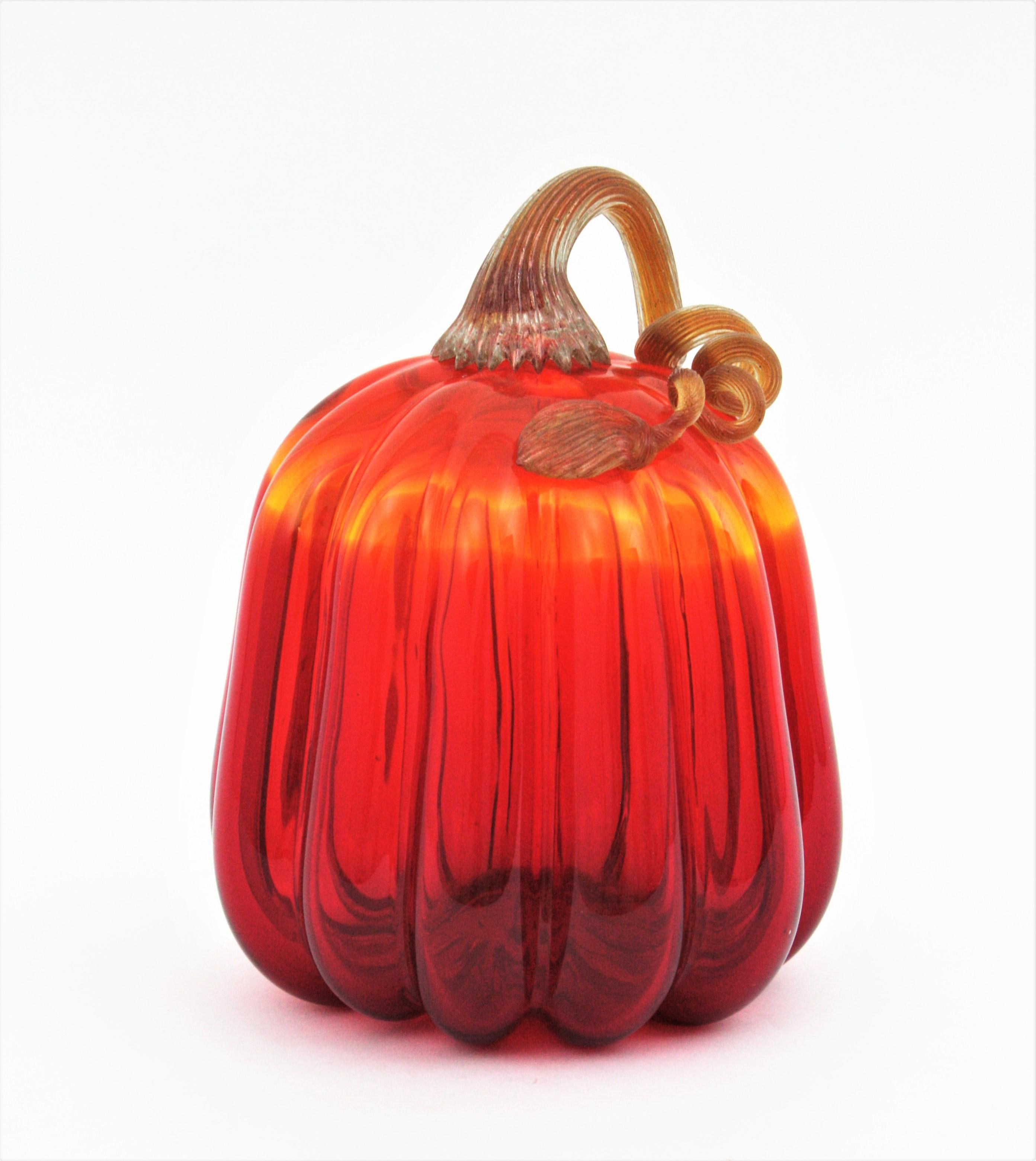 Amberina Murano Art Glass Pumpkin Sculpture with Gold Flecks, Italy, 1960s
A finely executed Murano Italian hand blown art glass figural pumpkin fruit sculpture having a amberina glass body in shades of orange to red with completed with a twisted