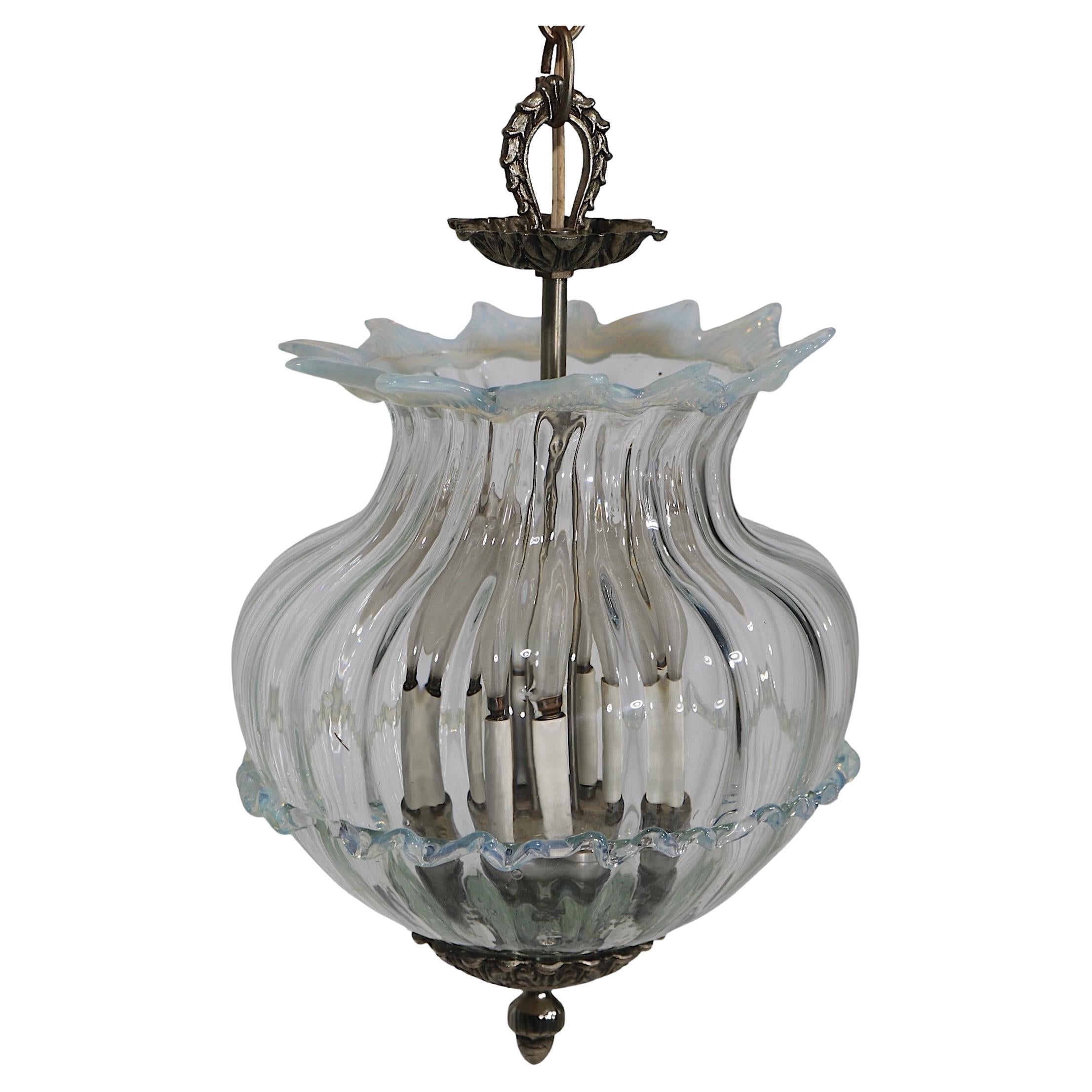 Elegant, voguish and chic art glass pendant  chandelier having an ornate bowl form globe, with rococo cast metal hardware. The glass element was made in Murano, Italy, with the metal elements made in the USA. The fixture was also  assembled and