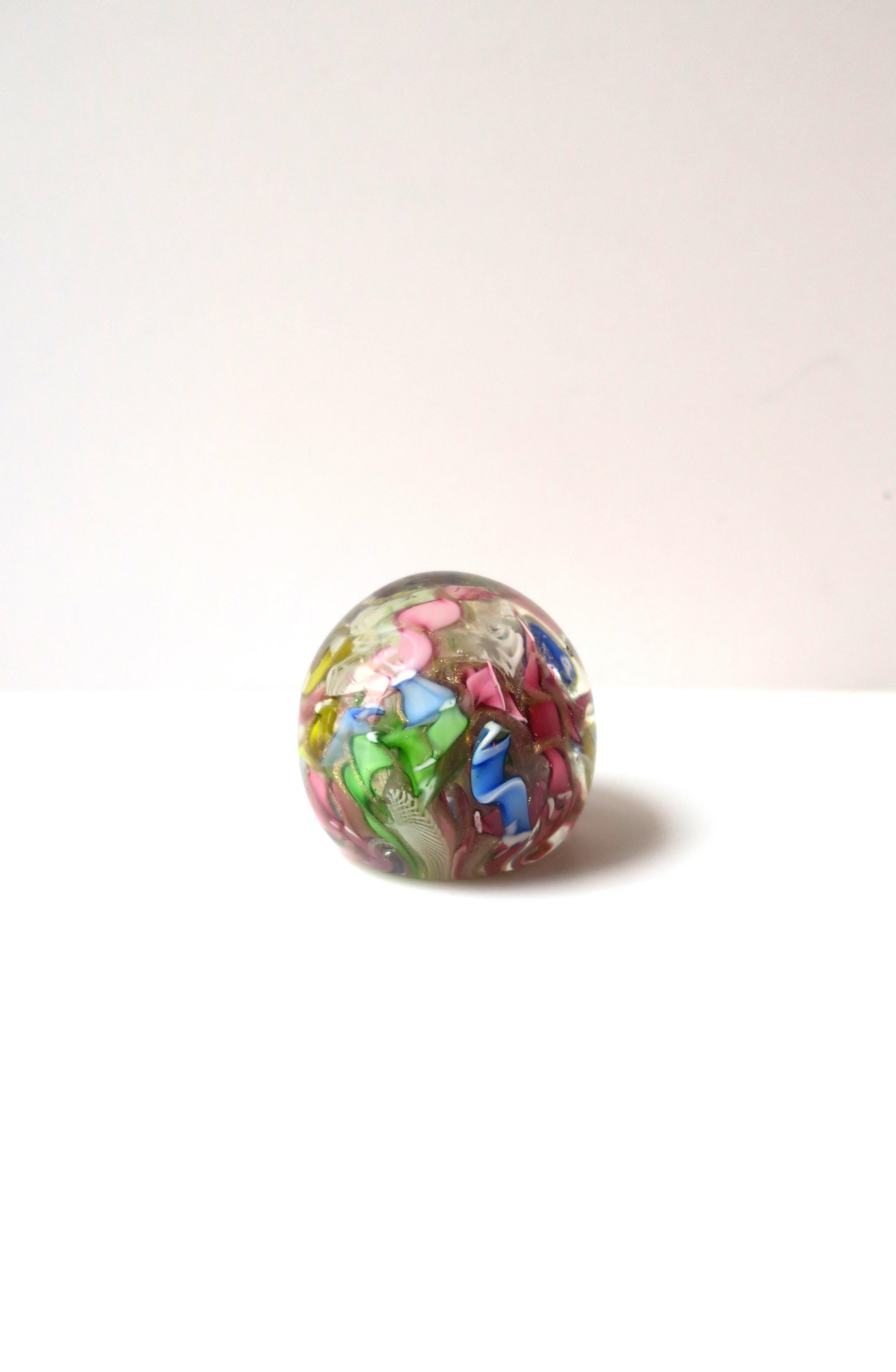 A beautiful vintage Italian Murano hand blown art glass paperweight, Midcentury Modern period, circa mid-20th century, Italy. Colors include pink, green, blue and white Zanfirico ribbon design. Piece maintains original label as shown in last two