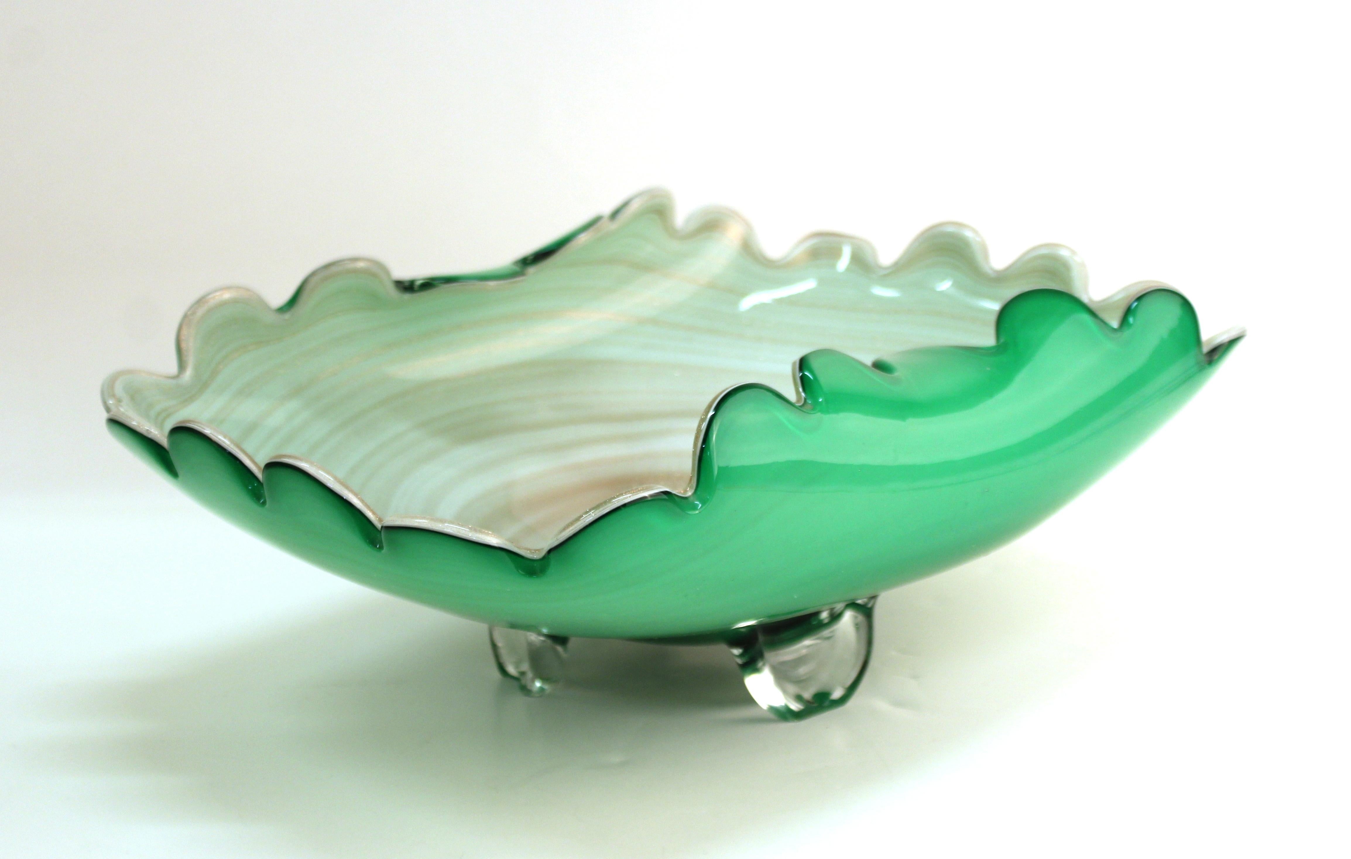 Italian modern art glass swirl bowl in green and cream with gold dust. The piece was made in Murano and features ruffled edges. In great vintage condition, with age-appropriate wear and a minor chip to one of the legs.