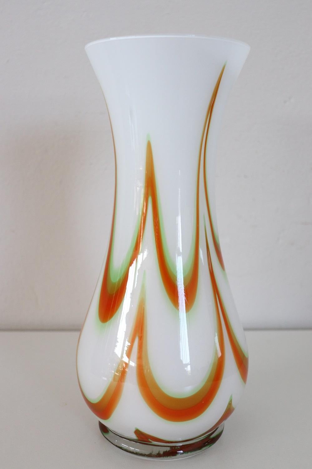 Refined artistic glass vase, Italy, production 1960s Murano. Non signé. High quality artistic in milky white color with a particular decoration reminiscent of kinetic art in the colors of orange. Perfect for an environment with furnishings from the
