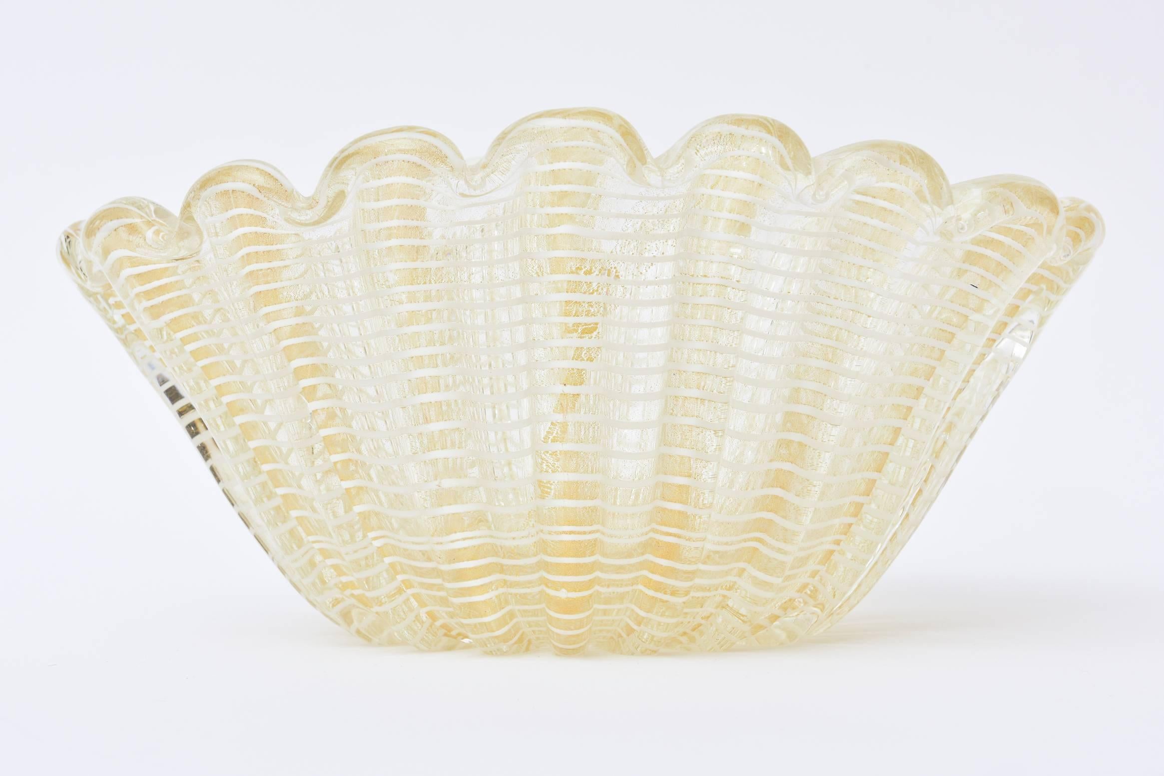 Este precioso y pesado cuenco italiano de cristal de Murano de mediados de siglo, obra de los maestros Barovier e Toso, tiene abundante aventurina dorada de 24 quilates contra el cristal transparente con diseño de telaraña blanca. Las inclusiones de