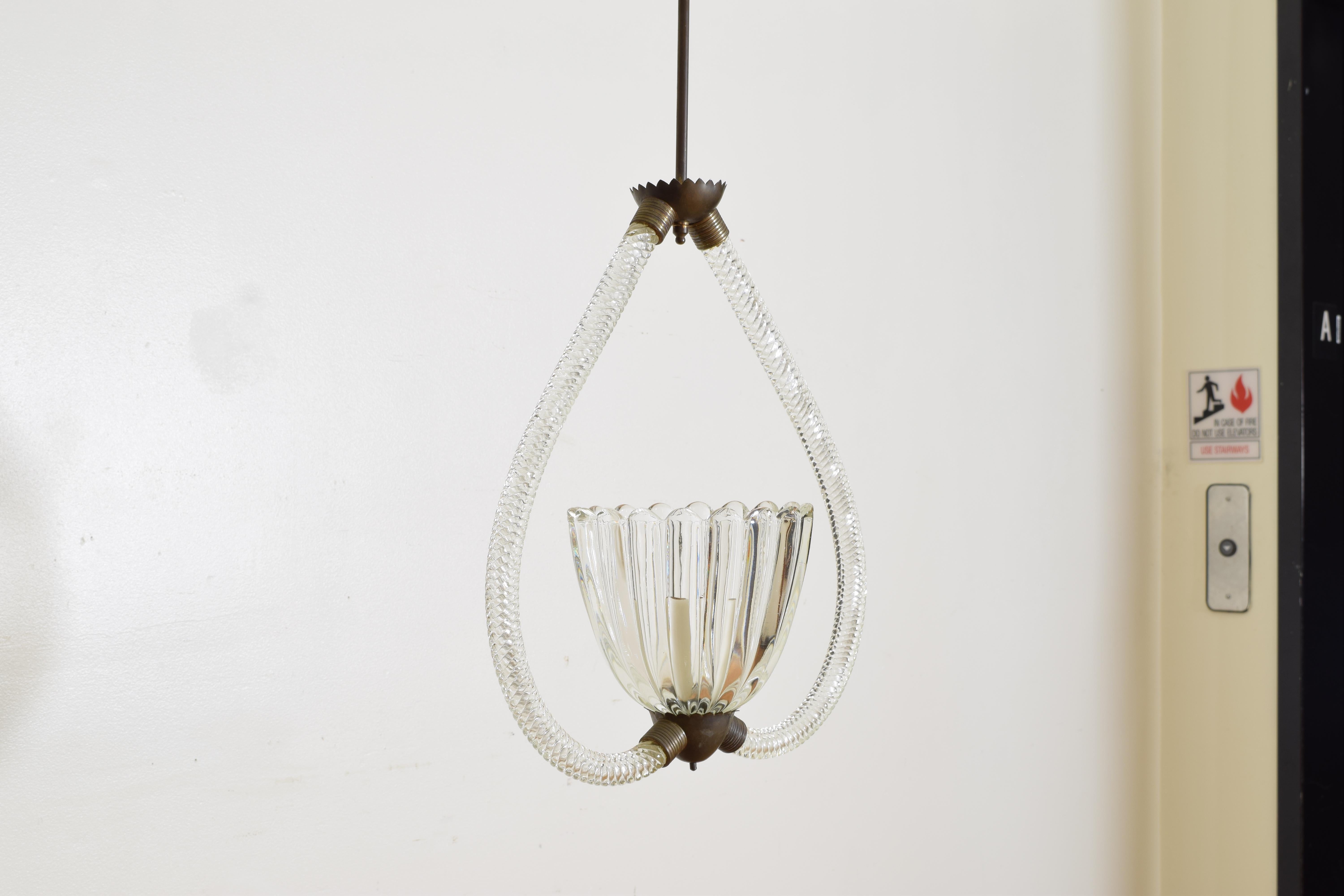 Hanging from a brass rod, the two blown and twisted glass arms curving to support a brass fitting issuing a large blown glass bobeche housing one socket