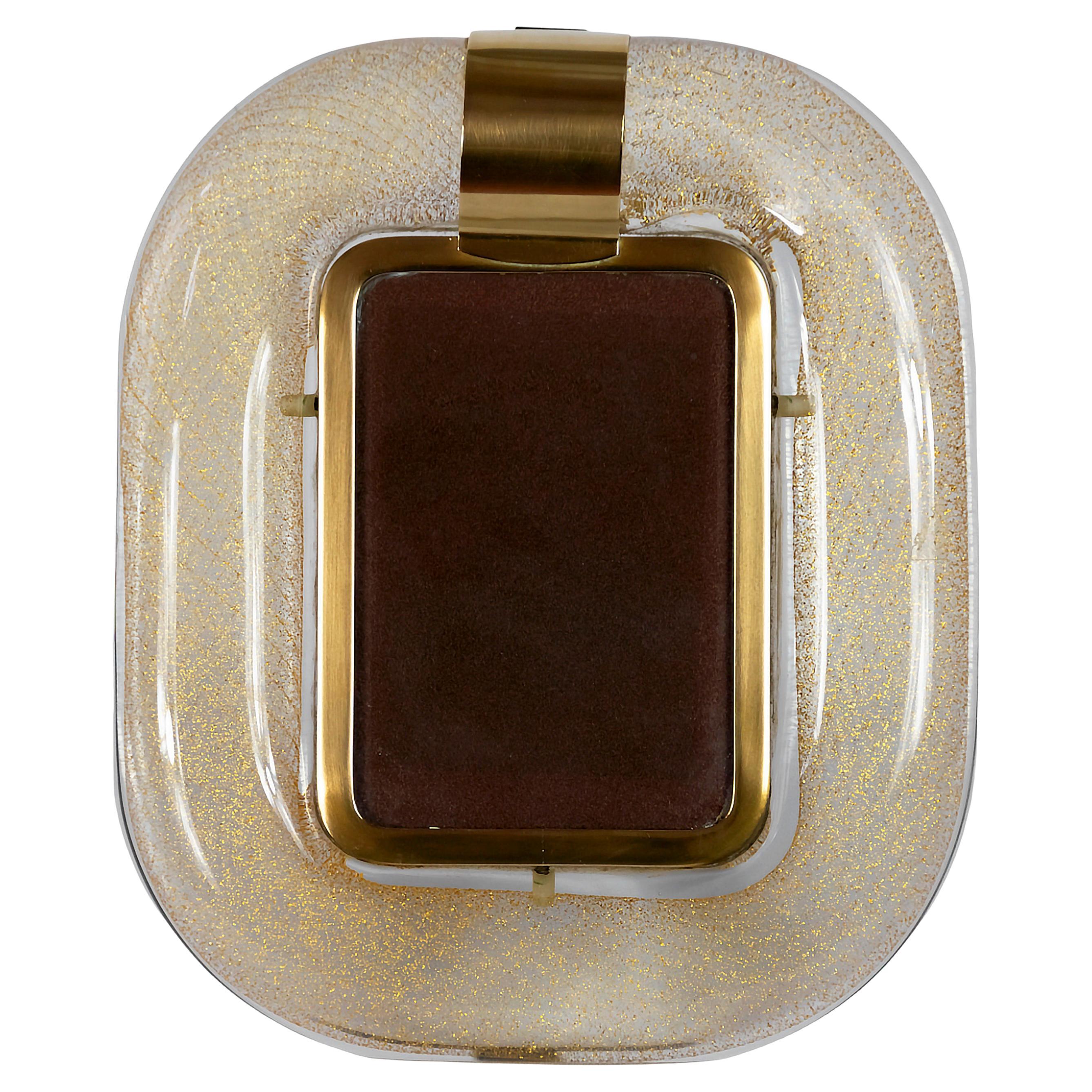 Italian Murano blown glass and brass photo frame by Tommaso Barbi from 1960's.
The glass is handmade, blown, transparent with gold dust inside.
Signed Tommaso Barbi made in Italy.
Very good condition.
 
