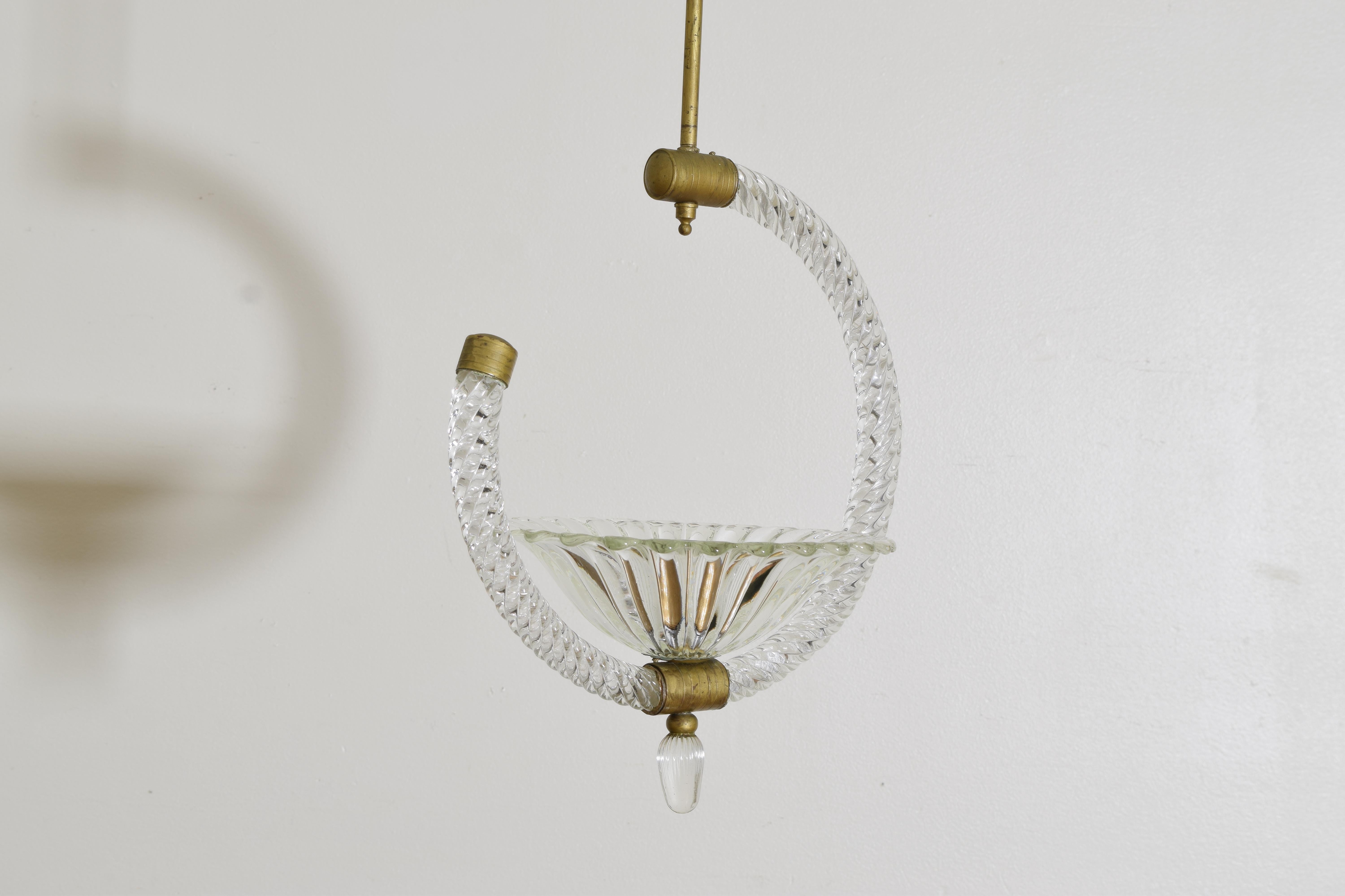 Hanging from a brass rod the curved and spiraled blown glass elements forming a C shape and joined by brass connectors, having one large shaped glass bobeche containing a single socket with a glass terminal, UL wired