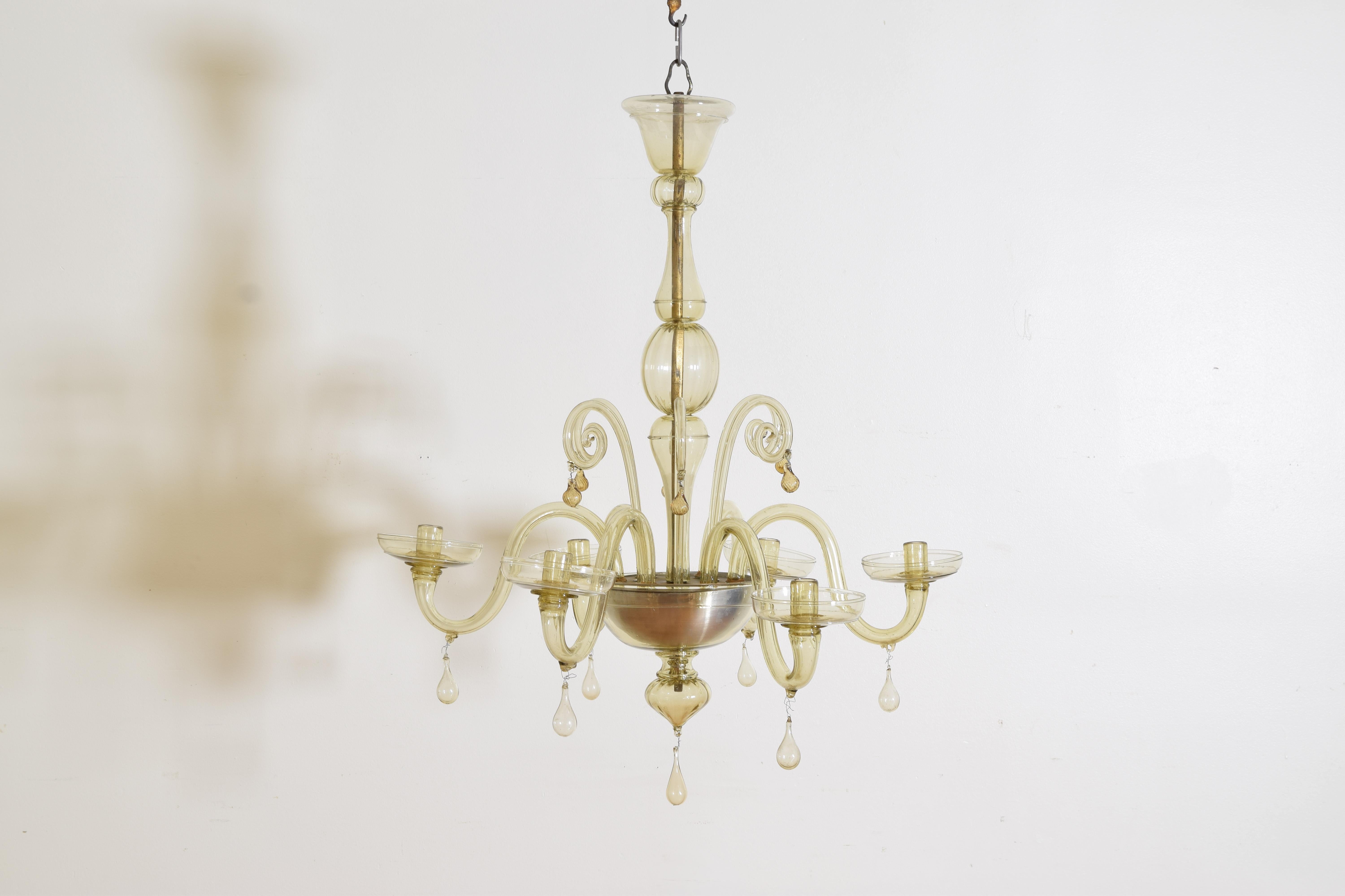 Having a 5-piece standard atop a base issuing 6 scrolls with tassels and curved arms with hanging tassels and large bobeches, the bottom of the base with a silvered metal liner, the terminal with a hanging tassel