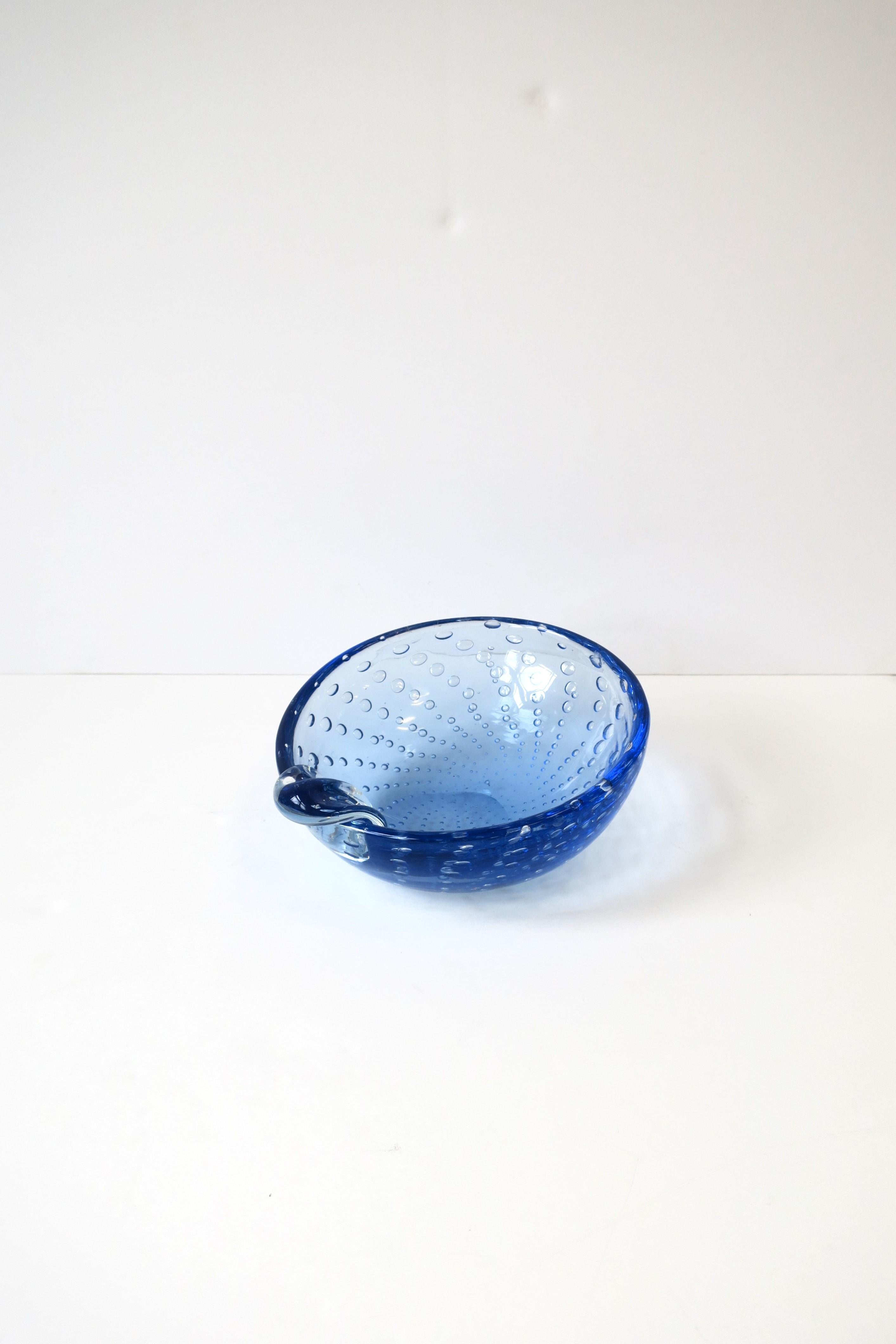 An Italian Murano art glass bowl or ashtray in the style of Seguso, circa mid-20th century, Italy. Bowl is a blue hue with a controlled bubble design. Great as a standalone piece, jewelry catchall, nut bowl, etc., or as an ashtray with its
