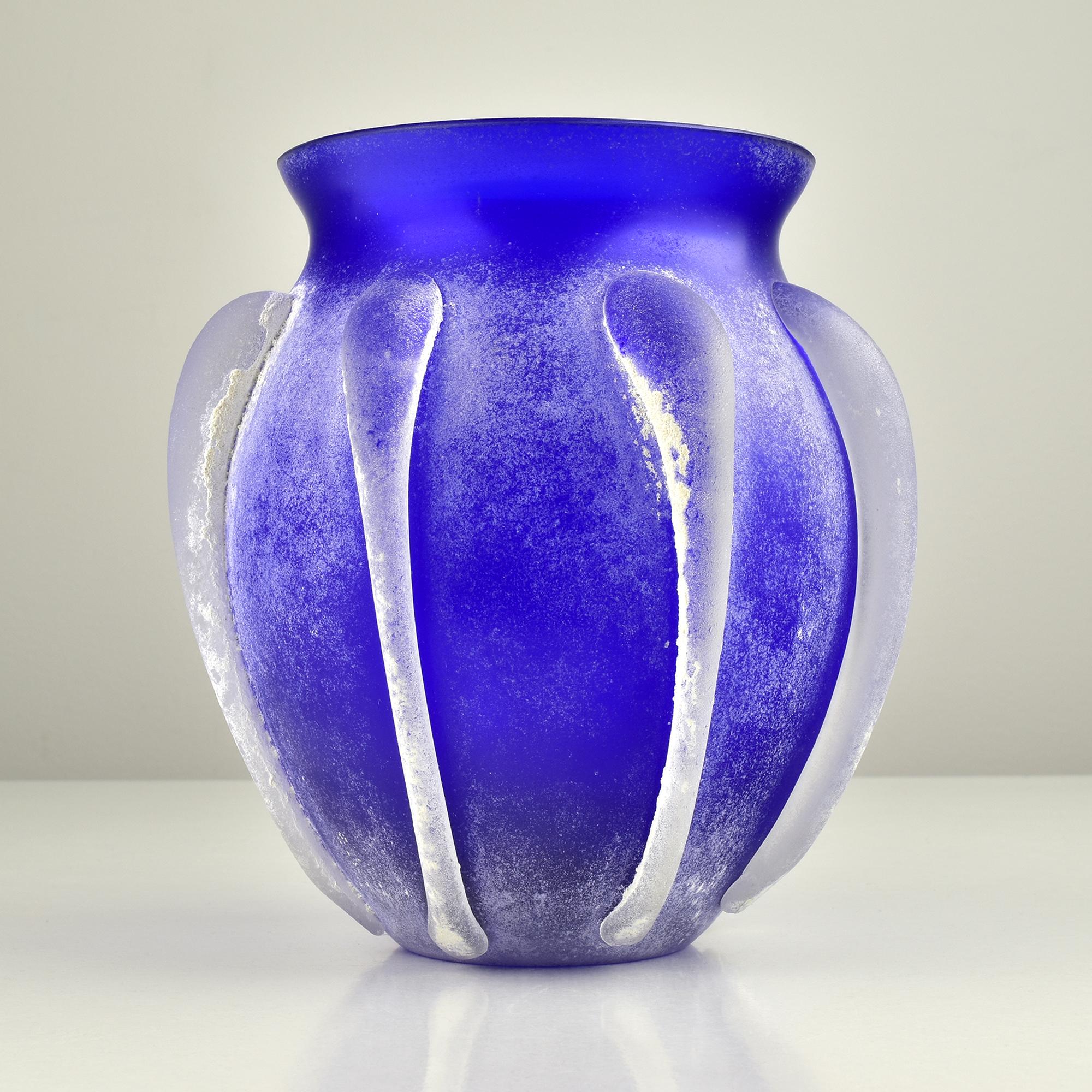 Questo vaso vintage di Murano Scavo in blu cobalto cattura l'essenza dell'arte vetraria italiana. La tecnica Scavo gli conferisce un aspetto antico e rovinato, che ricorda i manufatti dell'antichità. Il vaso è caratterizzato da una ricca tonalità di