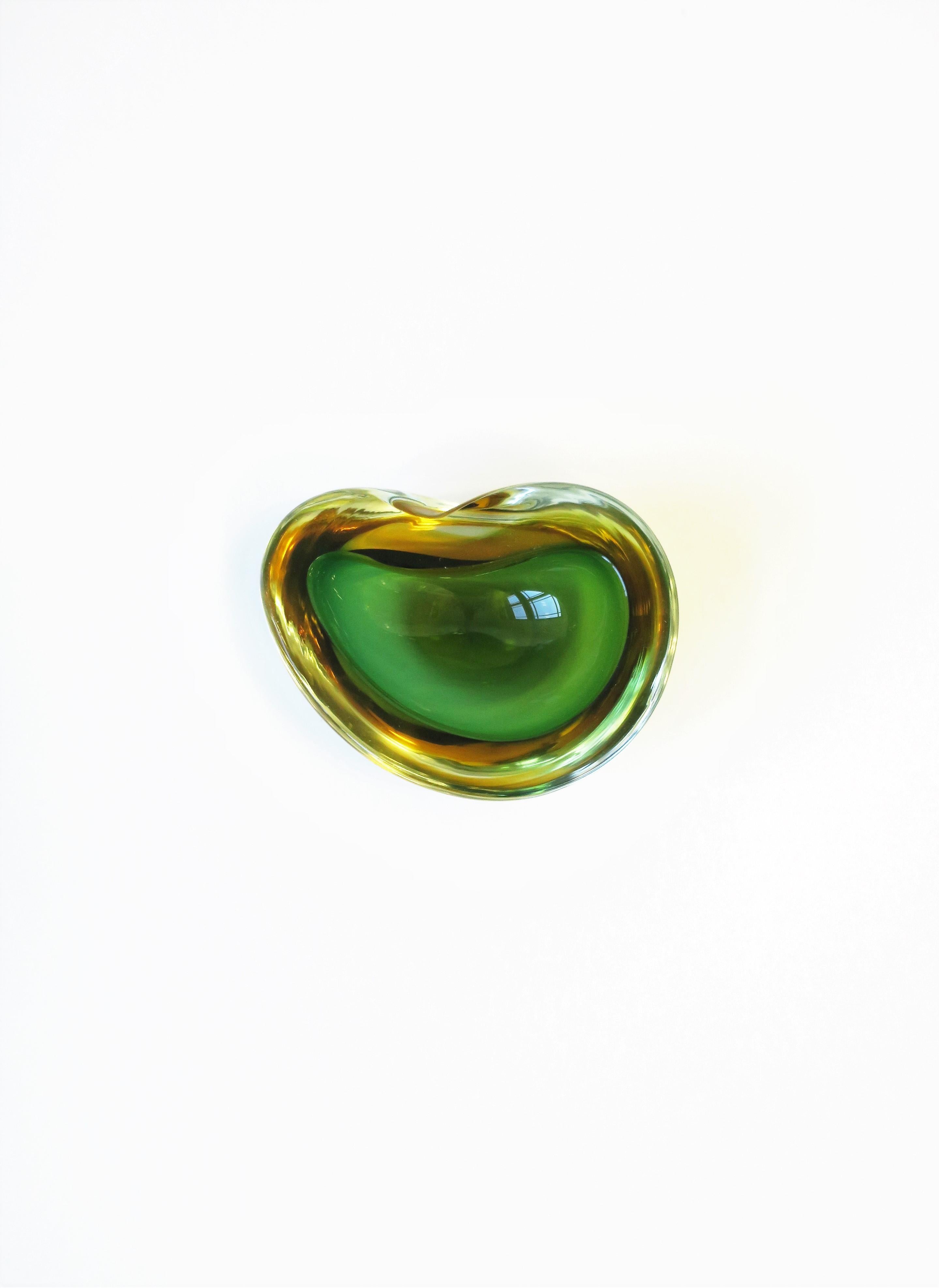 An Italian Murano emerald green and yellow art glass bowl in an organic modern form (a modern oyster seashell shape), circa mid-20th century, Italy. Great as a standalone piece and perfect for a side or drinks table for nuts, etc. Or, as a small