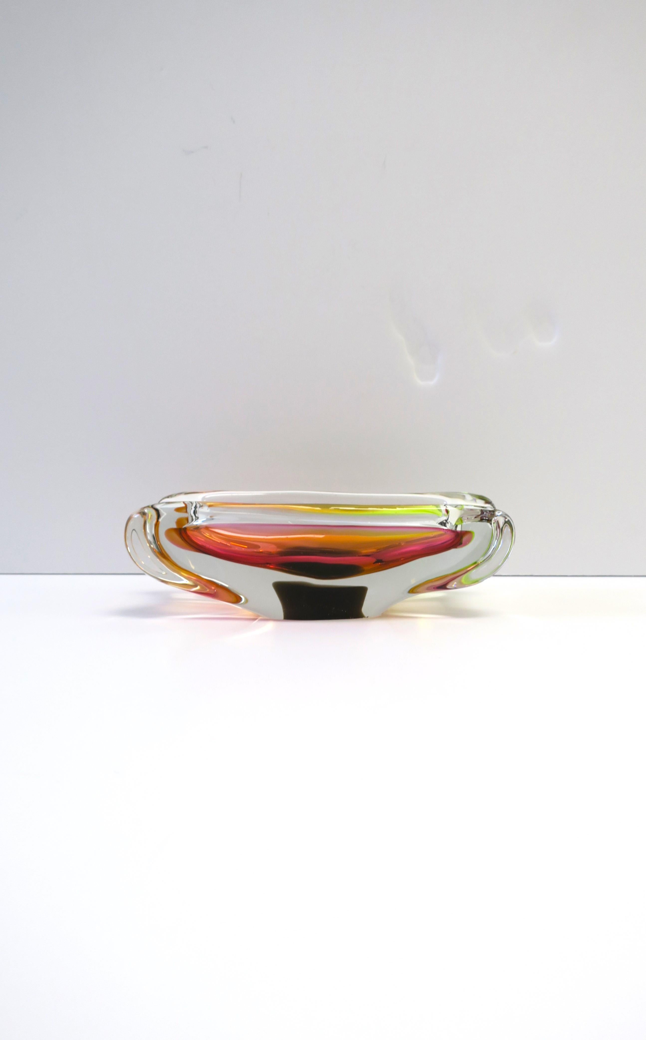 A beautiful Italian Murano art glass bowl or ashtray, circa mdi-20th century, Italy. This Italian Murano art glass bowl is hand-crafted, oblong design, with colors that include bright pink, orange, yellow/green (chartreuse), and dark brown accent at