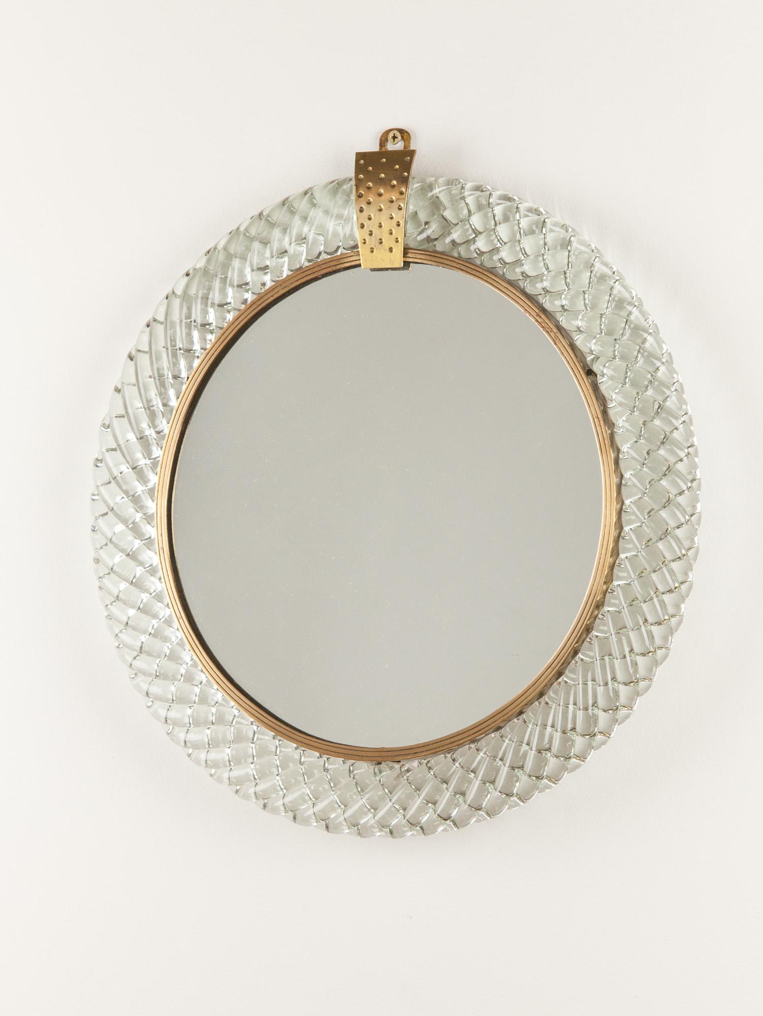 Vintage round wall mirror by Carlo Scarpa for Venini. The mirror is encased in a brass frame with the lovely ‘treccia’ (braided) Murano glass surround. Beautiful detailing is seen throughout from the brass frame to the Murano glass. Made in Italy in