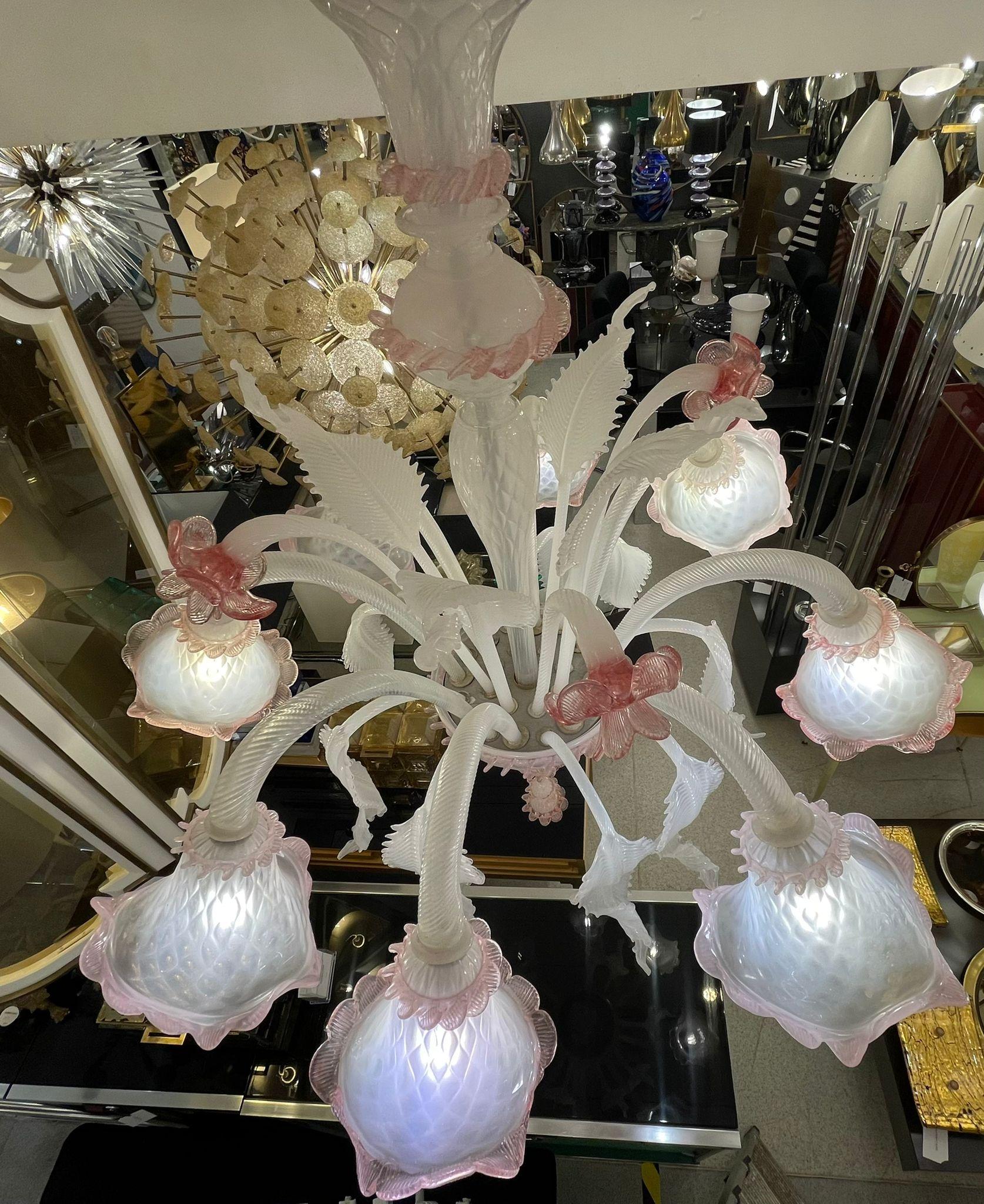 Murano chandelier 8 arms, pink vitreous paste flowers and leaves, details in pink and white. It is an evergreen model. The Murano glass techniques are a pride not only for the Venice area, but also for the entire made in Italy sector. The arms of