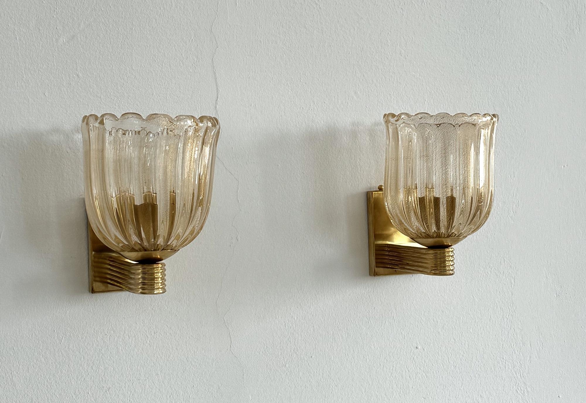 Appliques murales italiennes en verre de cristal de Murano et en laiton de style Art Déco

Magnifique ensemble de deux magnifiques et lourdes appliques murales en verre épais de Murano avec des paillettes d'or véritable à l'intérieur du verre et une