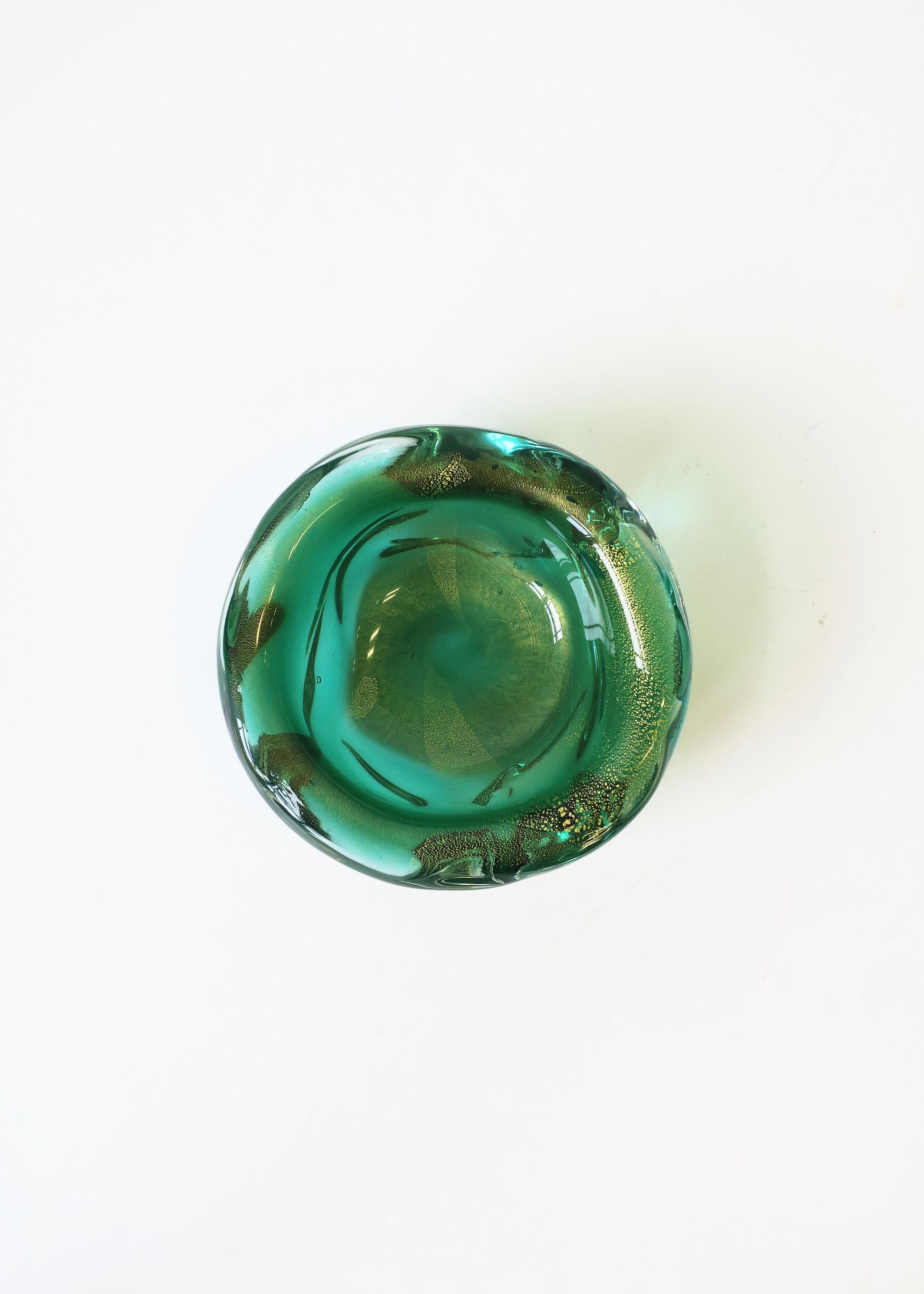 A beautiful and substantial Italian Murano bowl in an Emerald green and gold art glass, with soft edges in an organic modern form/style, circa mid-20th century, Italy. Great as a standalone piece or as a catchall vide-poche on desk, vanity, table,