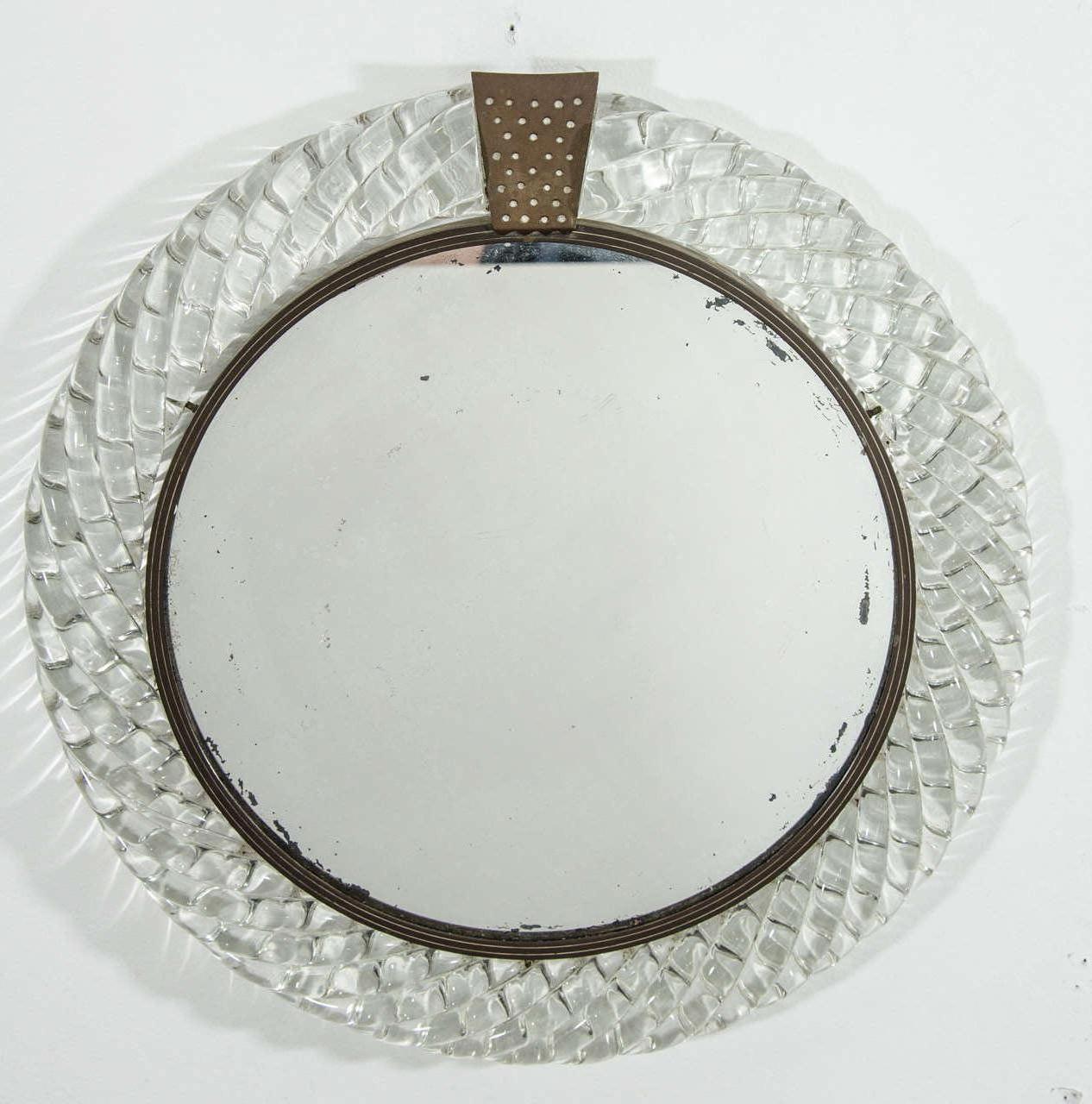 An Italian Murano clear art glass 'treccia' ('braid') framed round wall mirror with bronze decorative accent, circa mid-20th century, Italy. Mirror could work well in many areas including a vanity area or small space area such as a closet, dressing