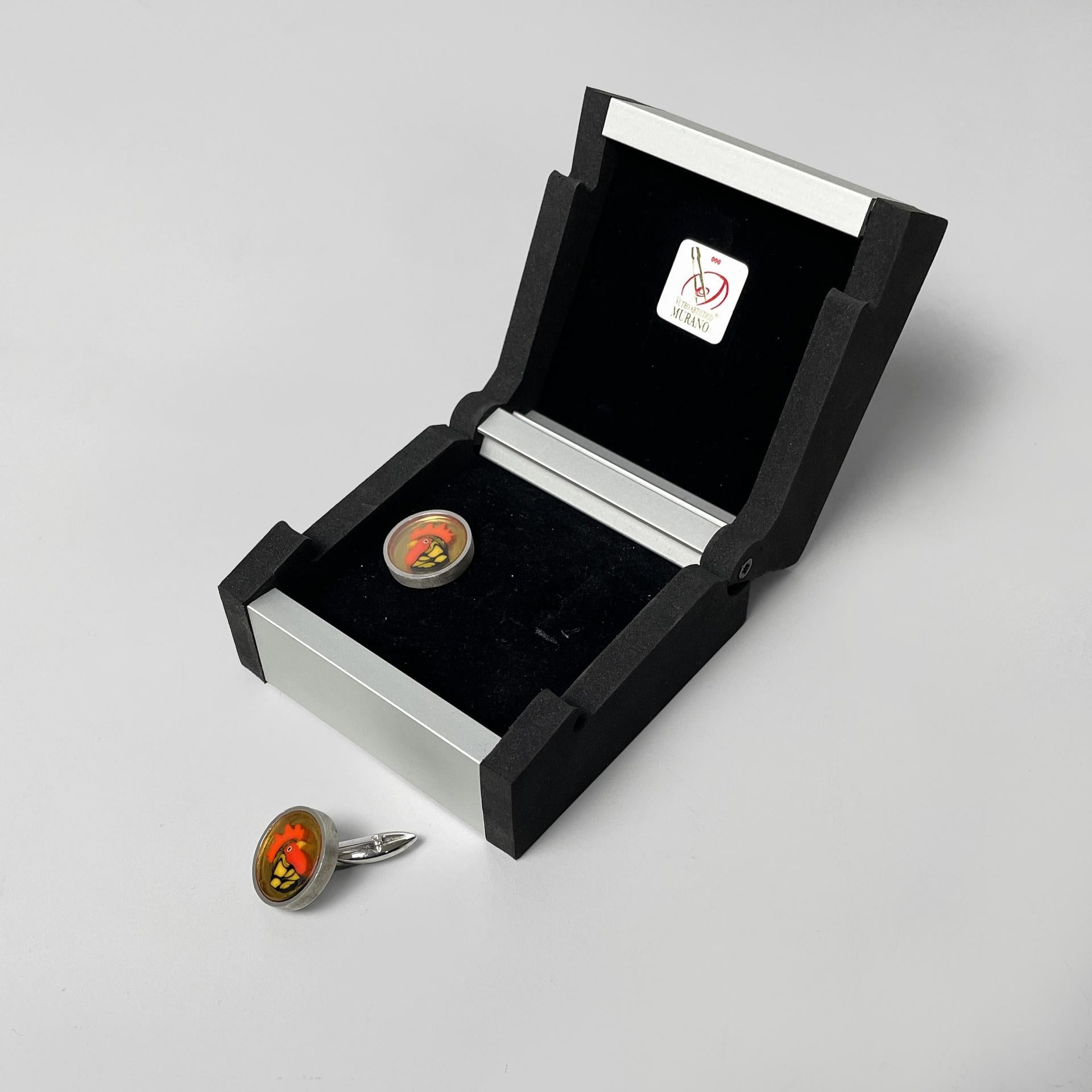 Italian Murano glass and 926 silver cufflink by Constantini Gioielli, 1990s
Pair of cufflinks with a rooster design in Murano glass. The structure is in 926 silver. Original metal and leatherette box.
Produced by Constantini Gioielli Venezia in