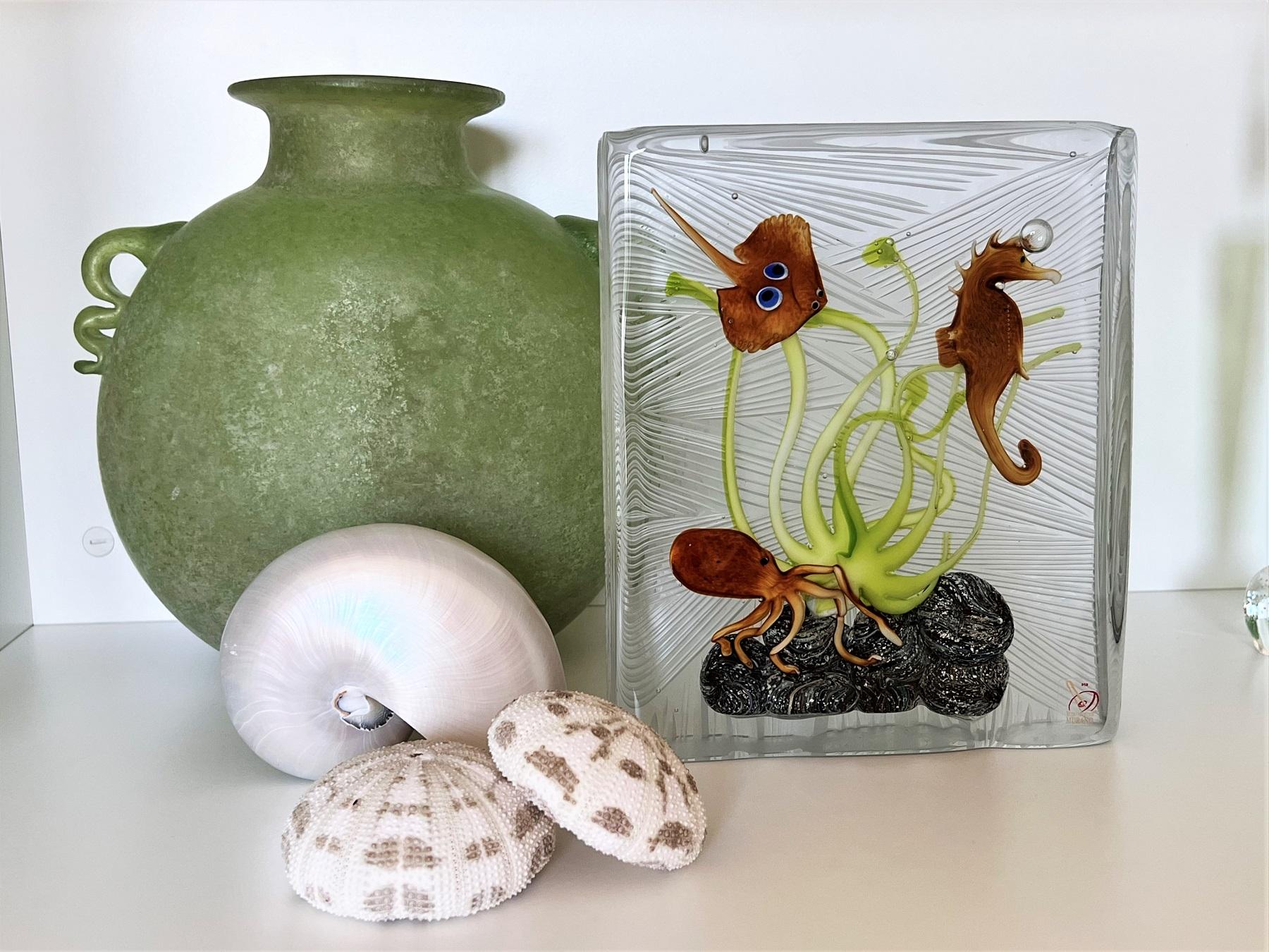 Very large Beautiful Murano aquarium made of glass showing sea animals and sea grass on rock.
The aquarium is handmade in many different steps and signed by the master Eugenio Ferro, Glassmaster of Murano.
The aquarium comes with the certificate of