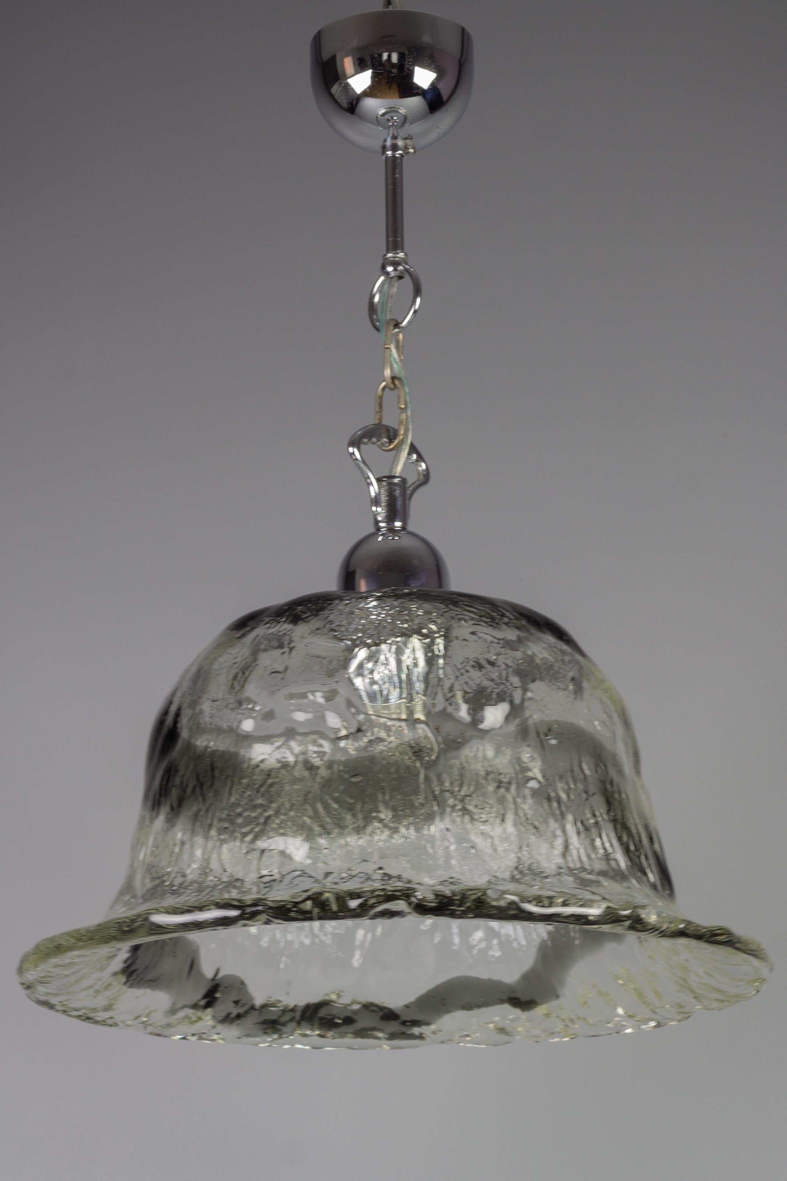 Impressive mid-century Italian Murano glass pendant light with chromed metal fitting. The beautiful thick clear and slightly gray smoked tone glass shade features a decorative blurry gray spiral-shaped line. Made in Italy in the 1970s, most probably