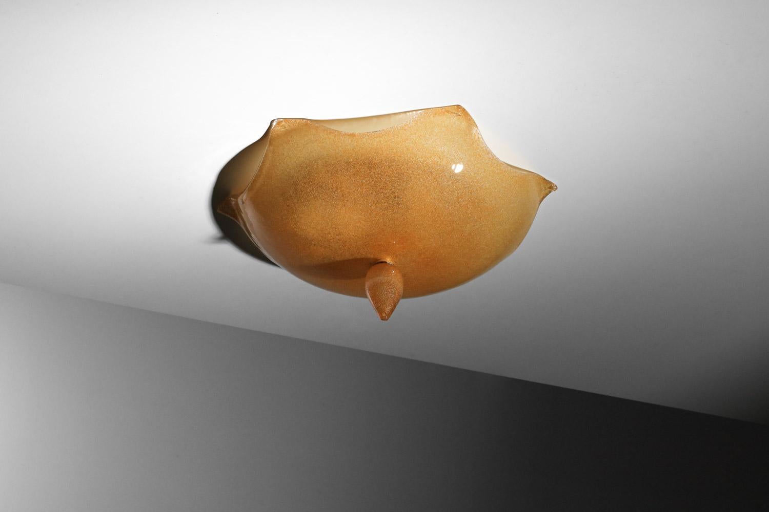 Plafonnier italien des années 1980, fabriqué par la manufacture La Murrina. Entièrement réalisé en verre de Murano orange granuleux, il est orné d'un grand cabochon en verre. La structure est en laiton et métal doré. Très bel état vintage avec une