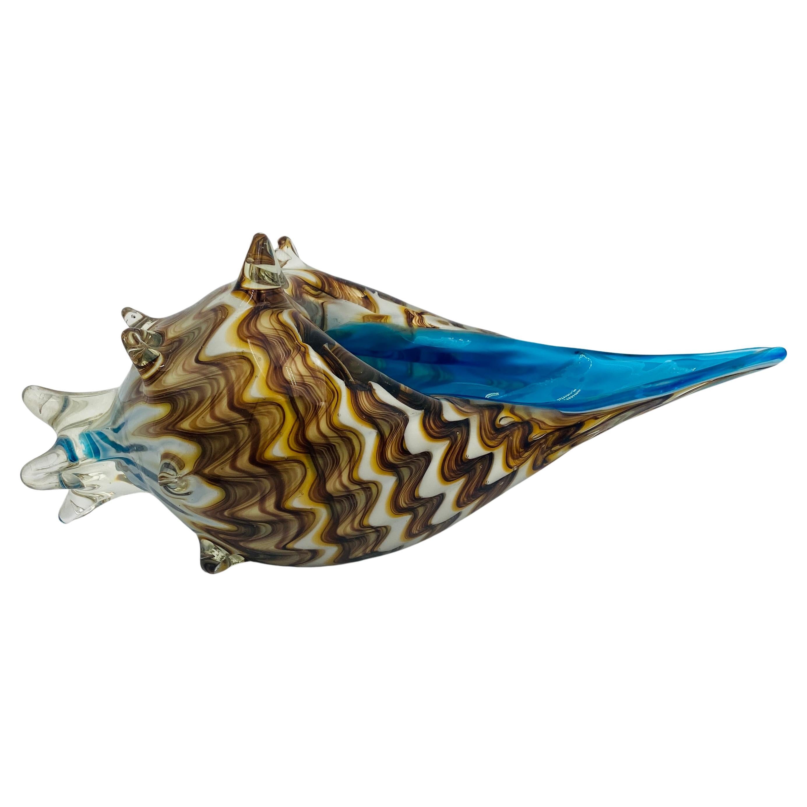 Eine Muschelschale aus Murano-Glas. Die in Italien handgefertigte Schale hat ein schönes Farbmuster mit einem dynamischen blauen Akzent im Inneren. Ein wunderbares Dekorationsstück für jeden Cocktailtisch, Schreibtisch, Regal oder Beistelltisch.