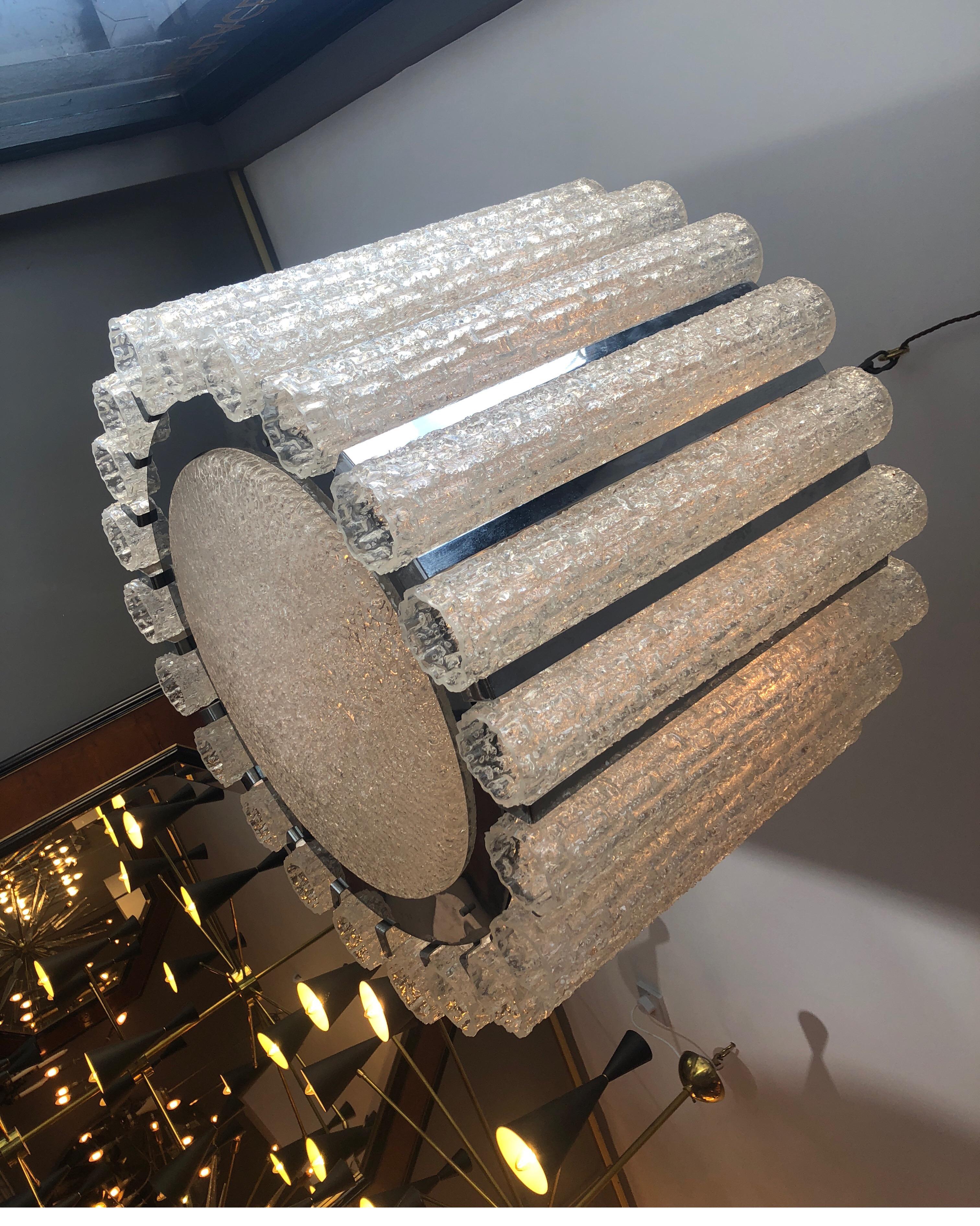 A large drum style chandelier in chrome with Murano glass tubular shades and matching glass dish shade beneath. Italian by Mazzega . Hung from chain which can be extended to any length. Sizes given in product details are of actual light fitting it