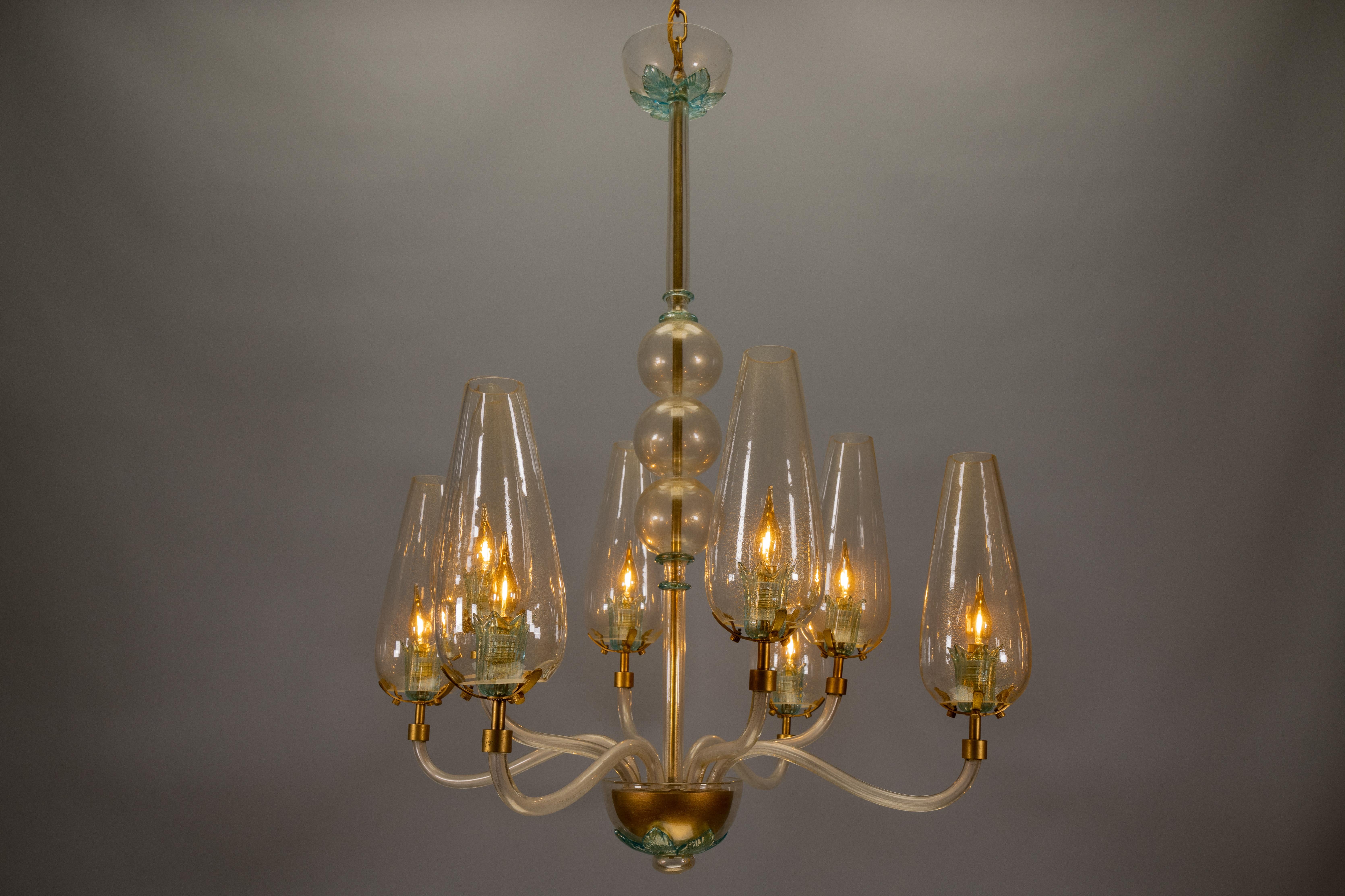 Rara lámpara de Murano de los años 70 con detalles dorados: una sorprendente pieza de diseño italiano.

Impresionante araña italiana de cristal de Murano de los años 70 con detalles dorados, que incluye ocho delicadas tulipas de cristal y elegantes