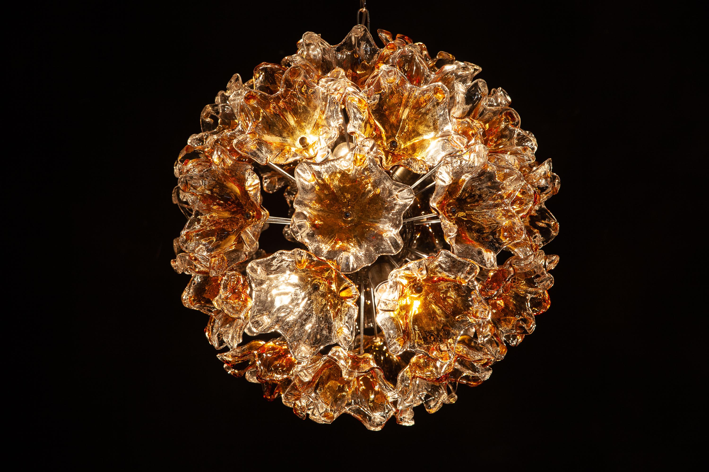 Large midcentury Sputnik chandelier composed of 38 precious hand blown Murano flowers art glasses with amber color inclusion. This amazing fixture fills the room with a warm and welcoming glow.
Chromed steel spherical frame, with six E 14