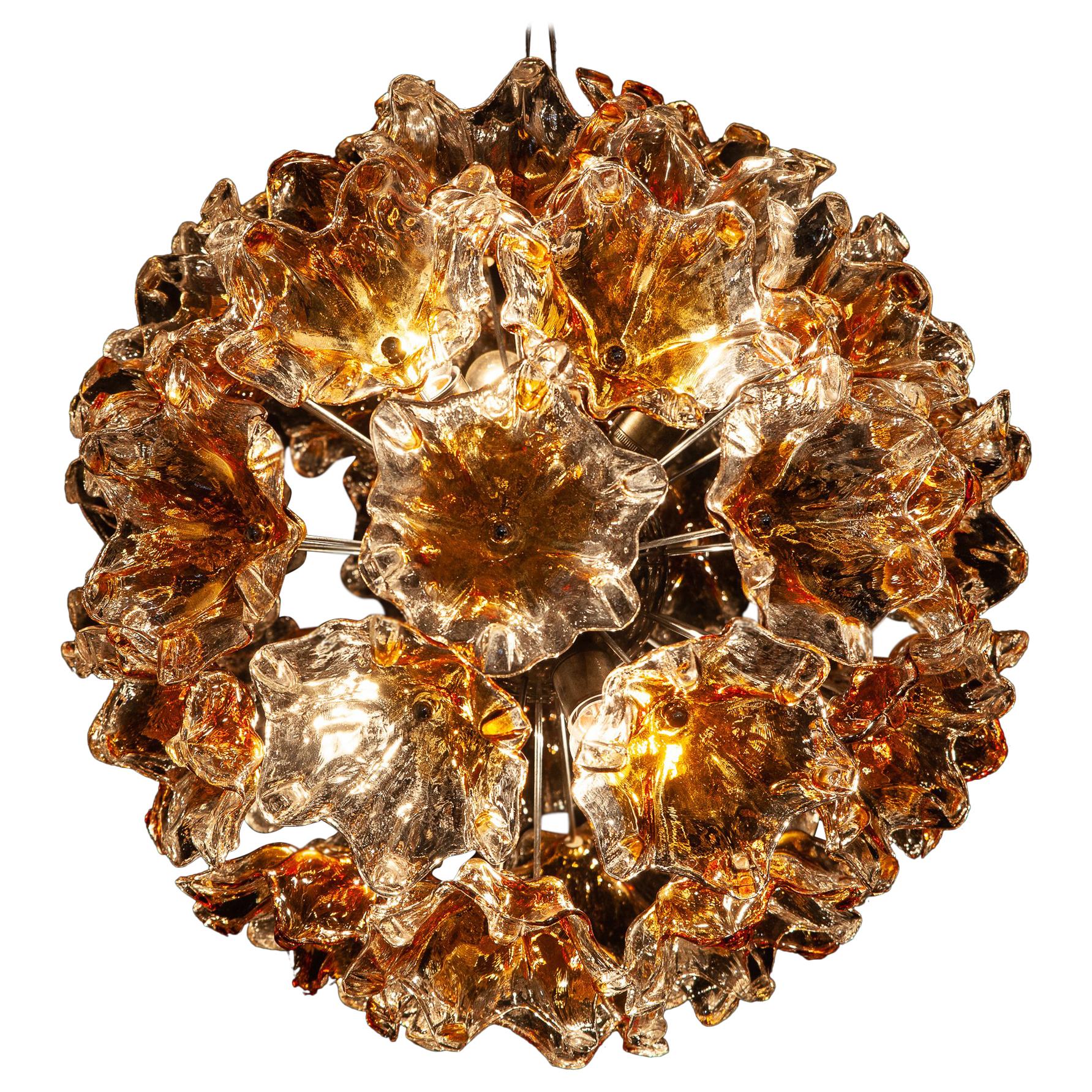 Large midcentury Sputnik chandelier composed of 38 precious hand blown Murano flowers art glasses with amber color inclusion. This amazing fixture fills the room with a warm and welcoming glow.
Chromed steel spherical frame, with six E 27 \ 5 W