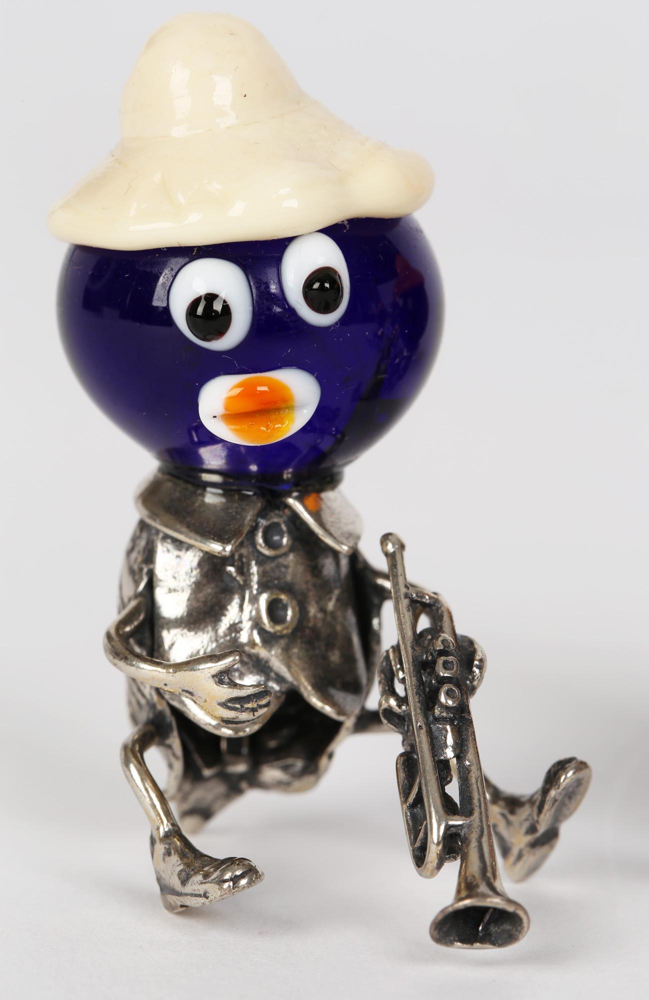 A delightful Italian novelty murano glass mounted silver band figures comprising of two banjo players and two trumpet players dating from the 20th century. The figures are modeled sitting and wearing jackets with tails and collars. The bodies are