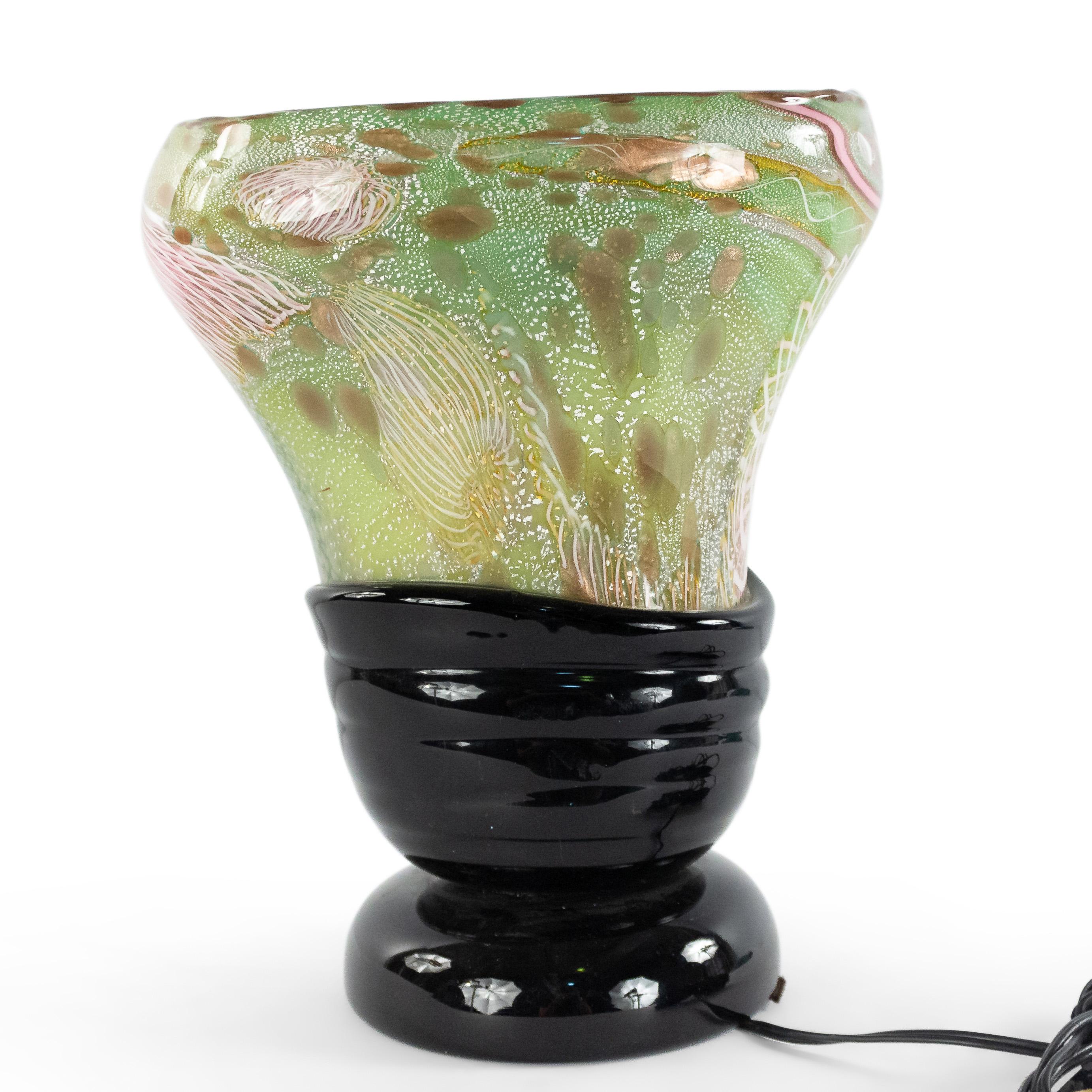 Italian 1960s Venetian Murano glass oval shaped table lamp of vase form with green, pink, and white freeform design on a round applied black glass base. (att: Nichetto).