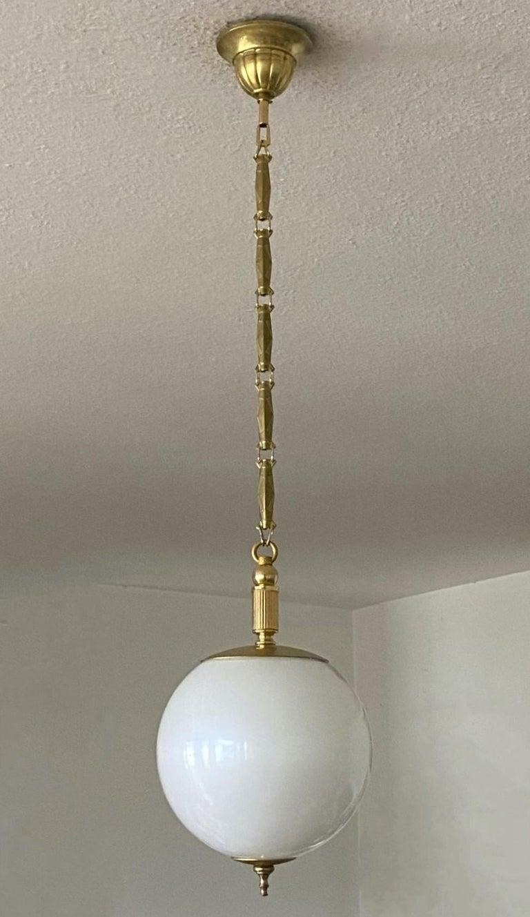 A lovely Murano glass globe pendant in pearl optic, brass mounts, chain and canopy, Italy, 1960s. This beautiful and rare pendant looks really like a big pearl hanging from the ceiling. With a single porcelain Edison E27 light socket for a large