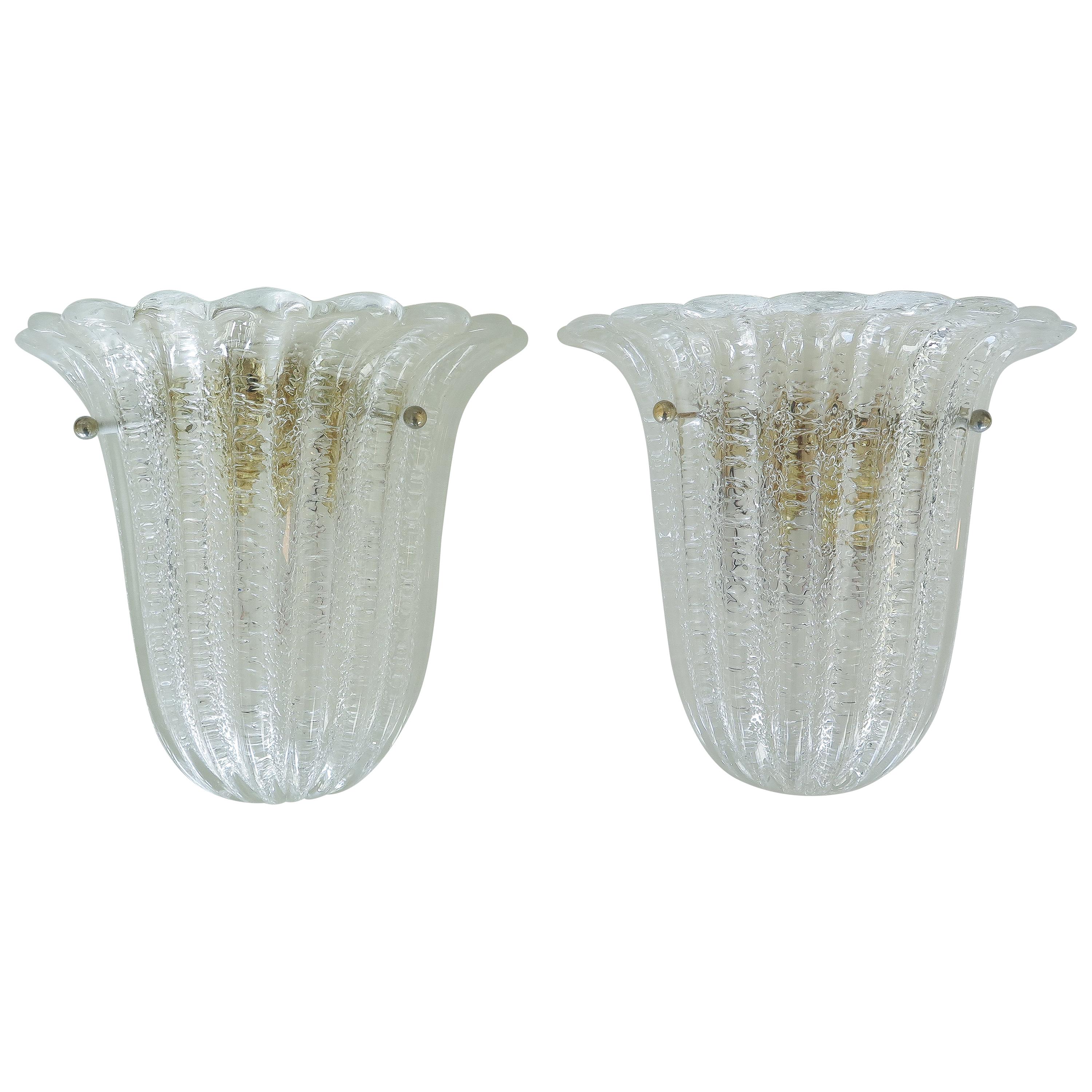 Beautiful pair of Italian Murano glass sconces by Barovier & Toso. Fluted shell shape with scalloped top edge, wavy ribbed glass and brass ball detailing. Brass-plated metal back plate with one socket, newly rewired.
5 sconces available, sold as