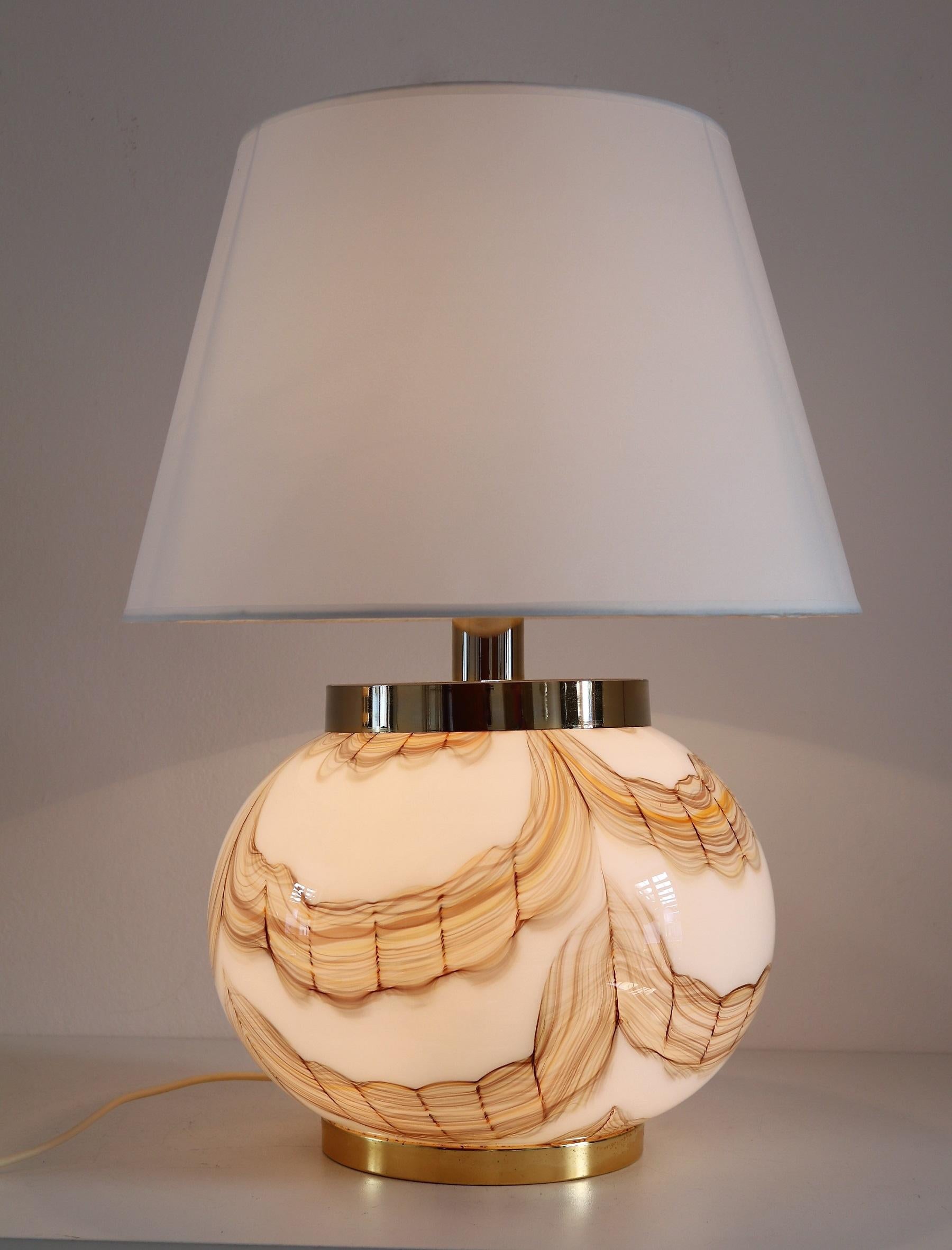 Gorgeous Italian table lamp with big Murano glass sphere base and golden metal details.
Made in Murano in the 1970s.
The glass is stunning to see with its different color nuances from different browns over orange to yellow.
The lamp has four