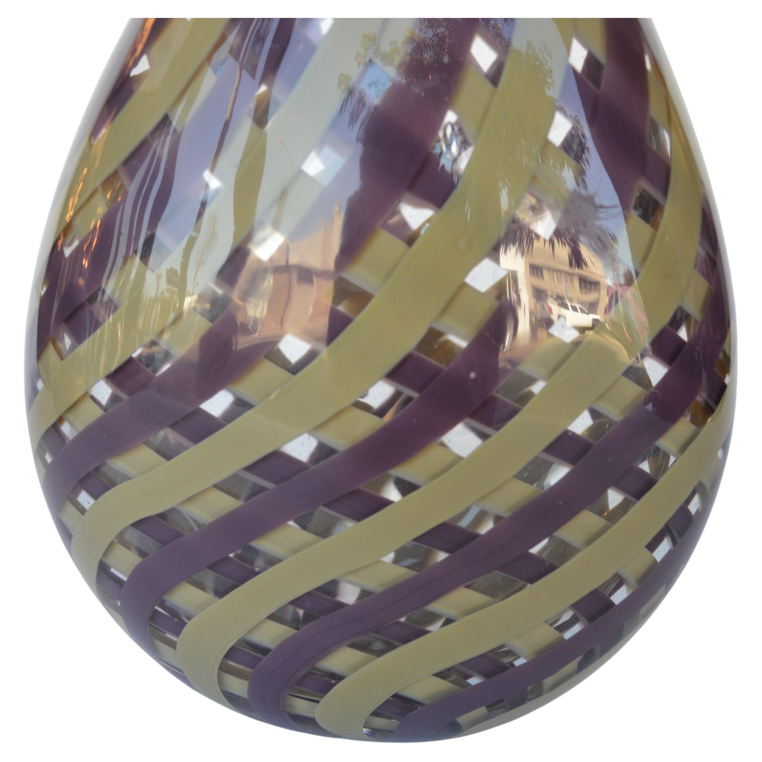 Vase aus italienischem Muranoglas, mundgeblasen, mit lila und senfgelben Streifen, die sich miteinander verflechten. Hergestellt in Italien, ca. 1970er Jahre. Eingravierte Muranomarke auf dem Sockel.