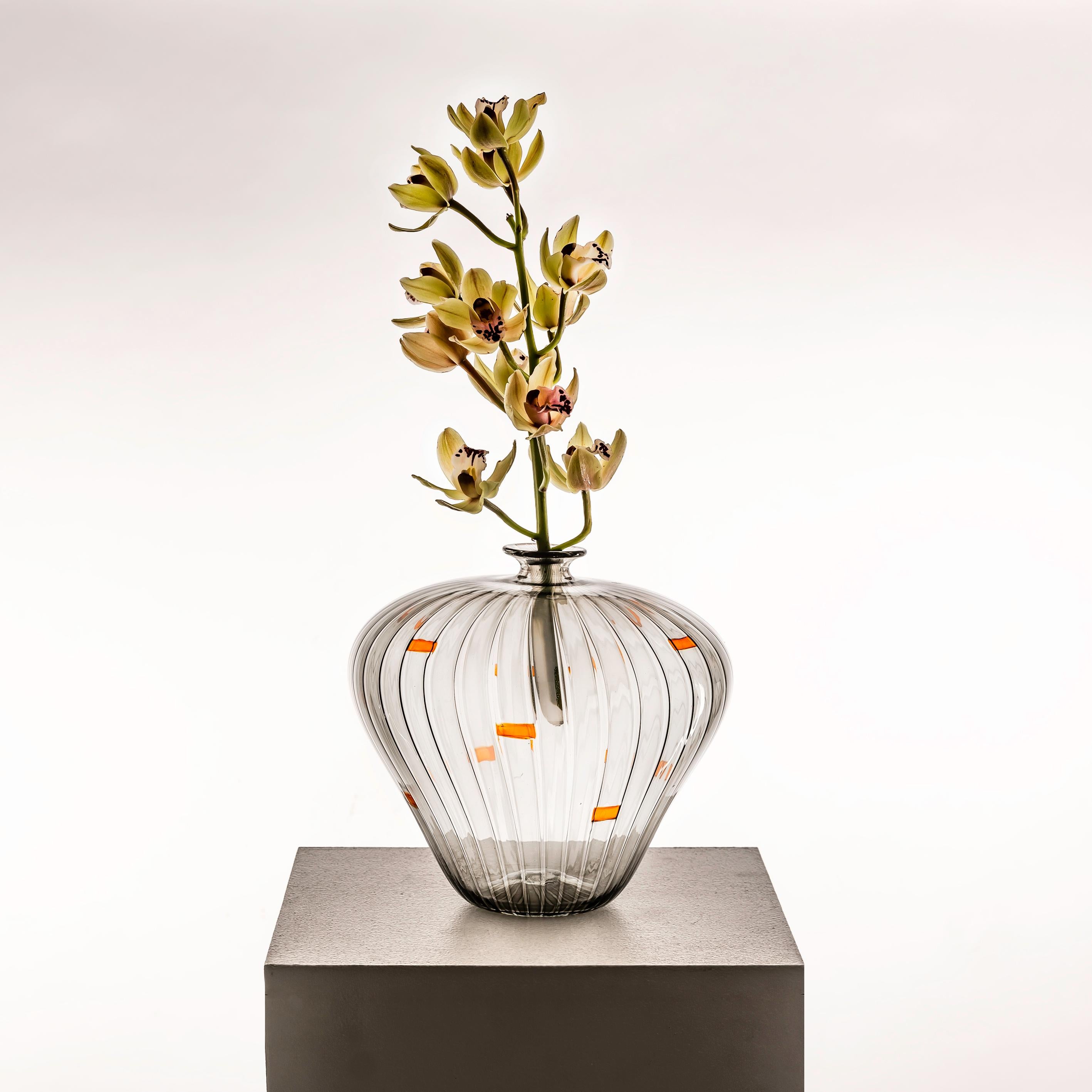 Dive into the mesmerizing beauty of an Italian Murano Glass Vessel by Orlando Zennaro, a sublime creation from the 1970s. This exquisite piece, in shades of grey with vibrant orange inclusions, reflects Zennaro's mastery of Murano glass artistry.