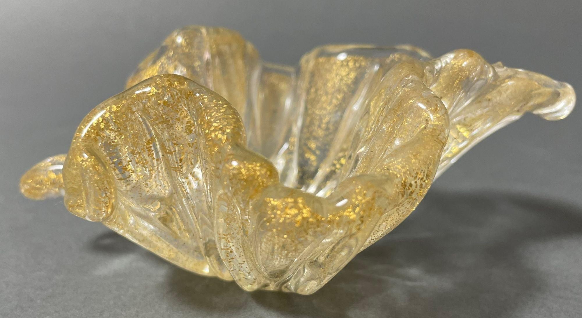 Vintage Murano Archimede Seguso Gold Flecks Leaf Dish attribué à Barovier e Toso.
Ce magnifique petit plat en verre soufflé à la main de Murano date de la fin des années 50 ou du début des années 60.
Il s'agit d'une feuille d'or avec aventurine
