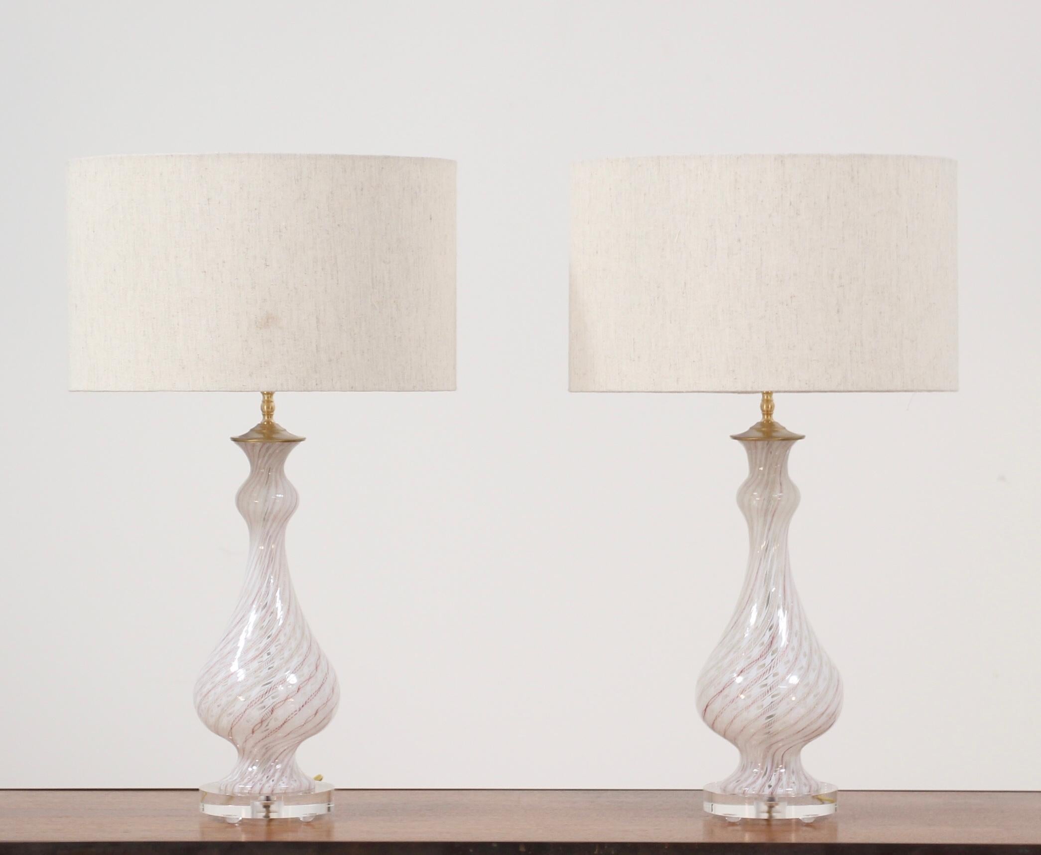 Pair of 1960s Italian Murano latticino glass lamps in a white, gold and red color way. These elegant lamps have been newly wired, their brass hardware has been polish and they have been mounted on new acrylic bases to complement their modernity. We