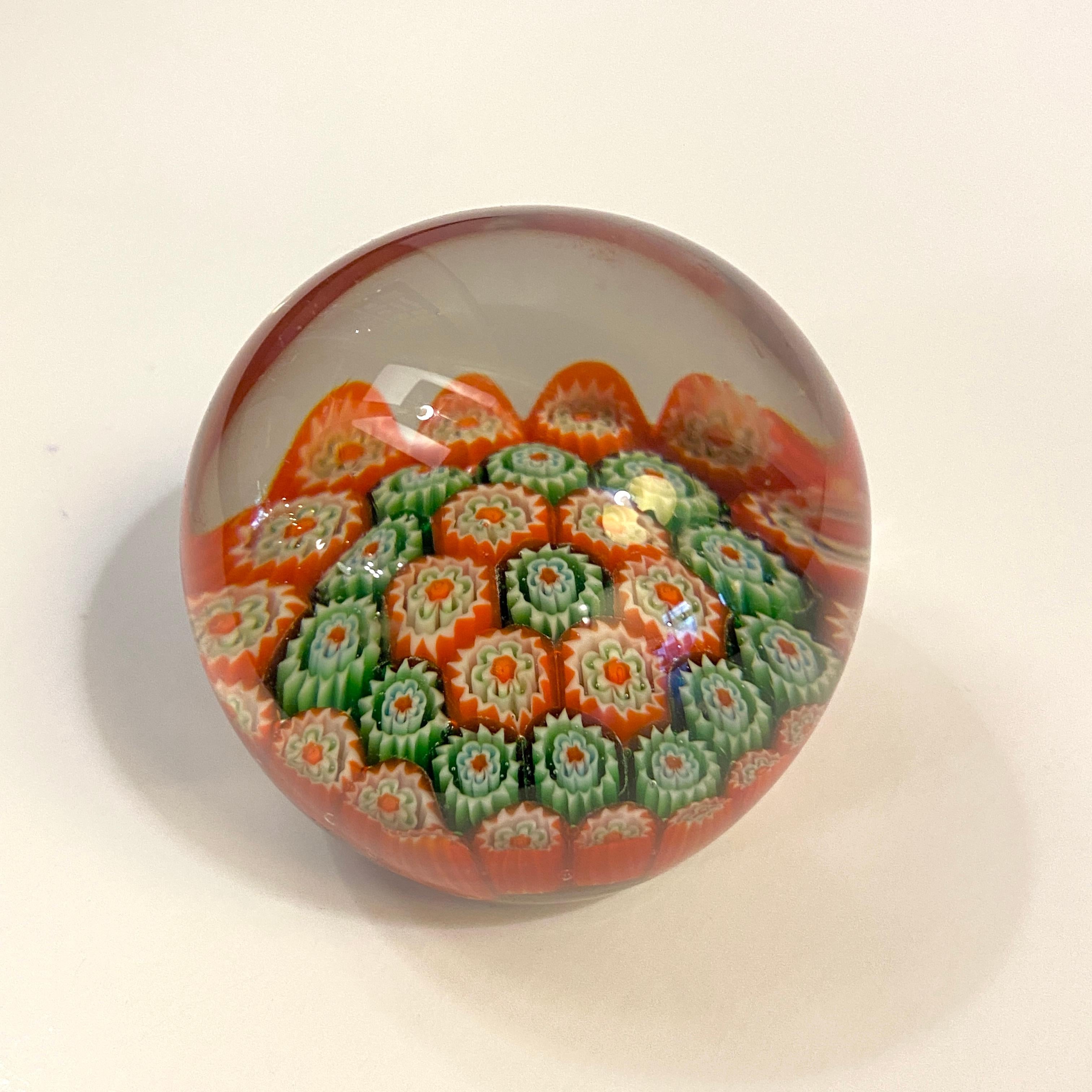 Petite, Italian Murano, hand-blown, art glass paperweight with red, green and white millefiori (a thousand flowers) technique enclosed in clear glass. Circa mid to late-20th century, Italy.  A great decorative object or paperweight. 